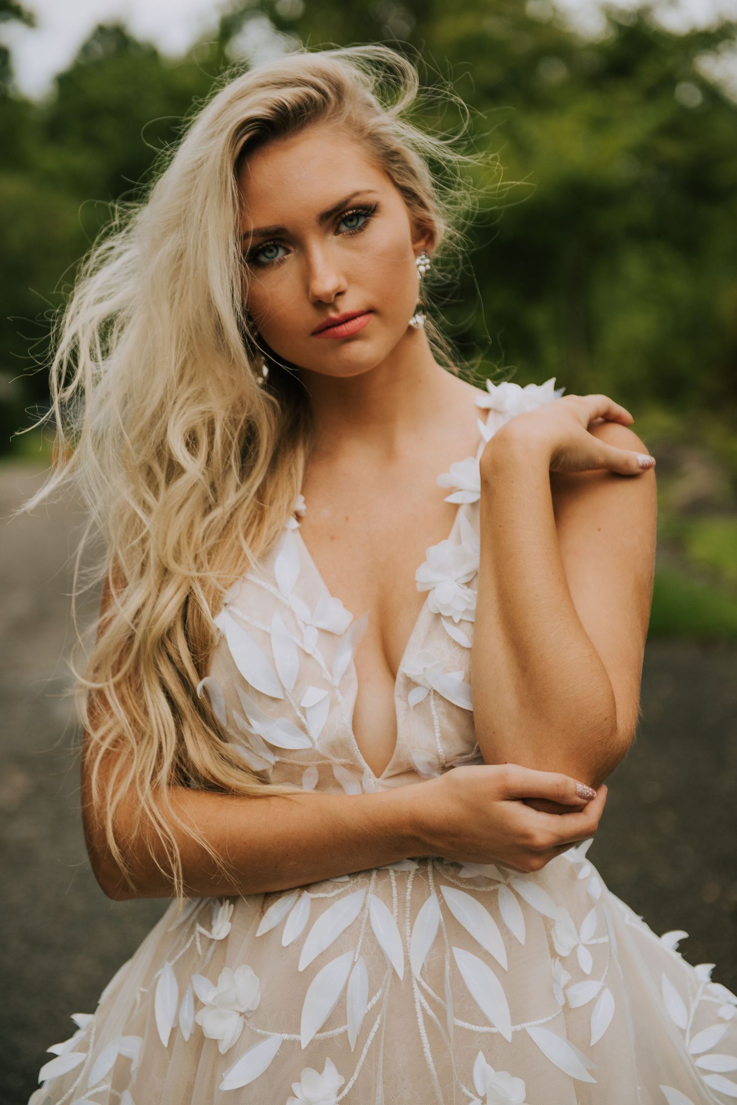 Fashion portrait featuring an ethereal white dress with leaf details in a natural outdoor setting.