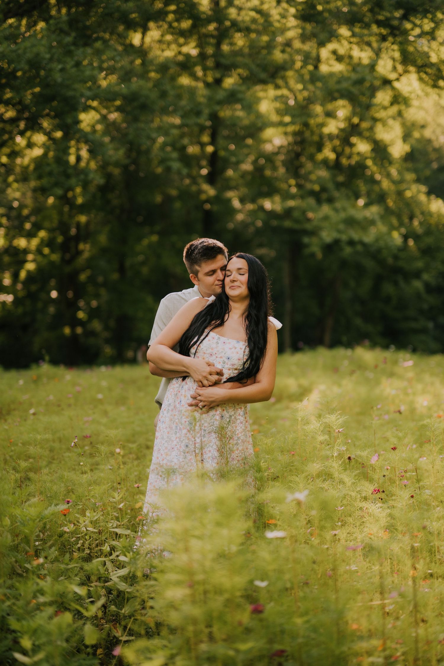 A tender moment captured between a couple in a sunlit meadow during golden hour.