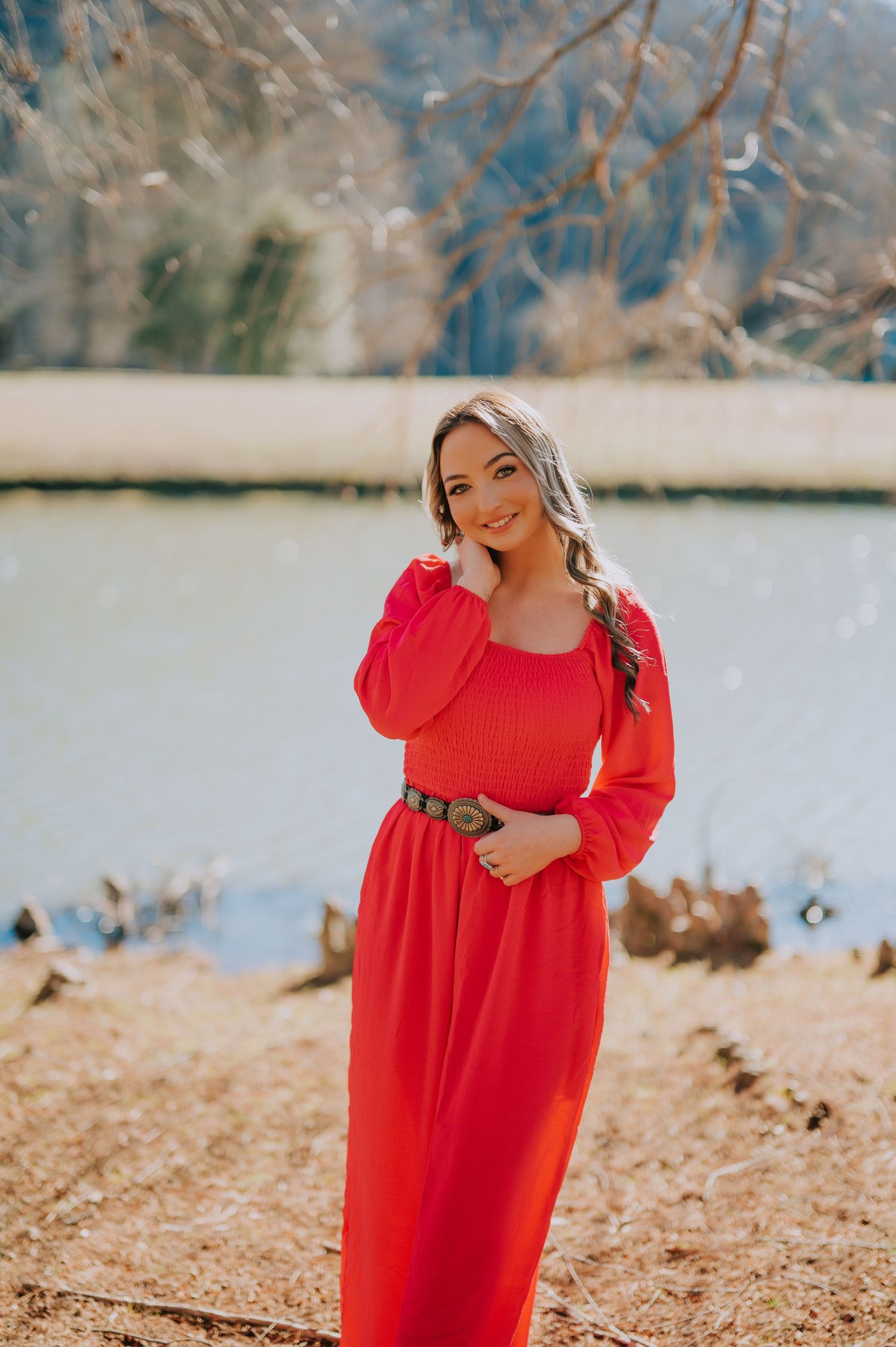 A peaceful lakeside setting with pine trees and rocky shoreline.