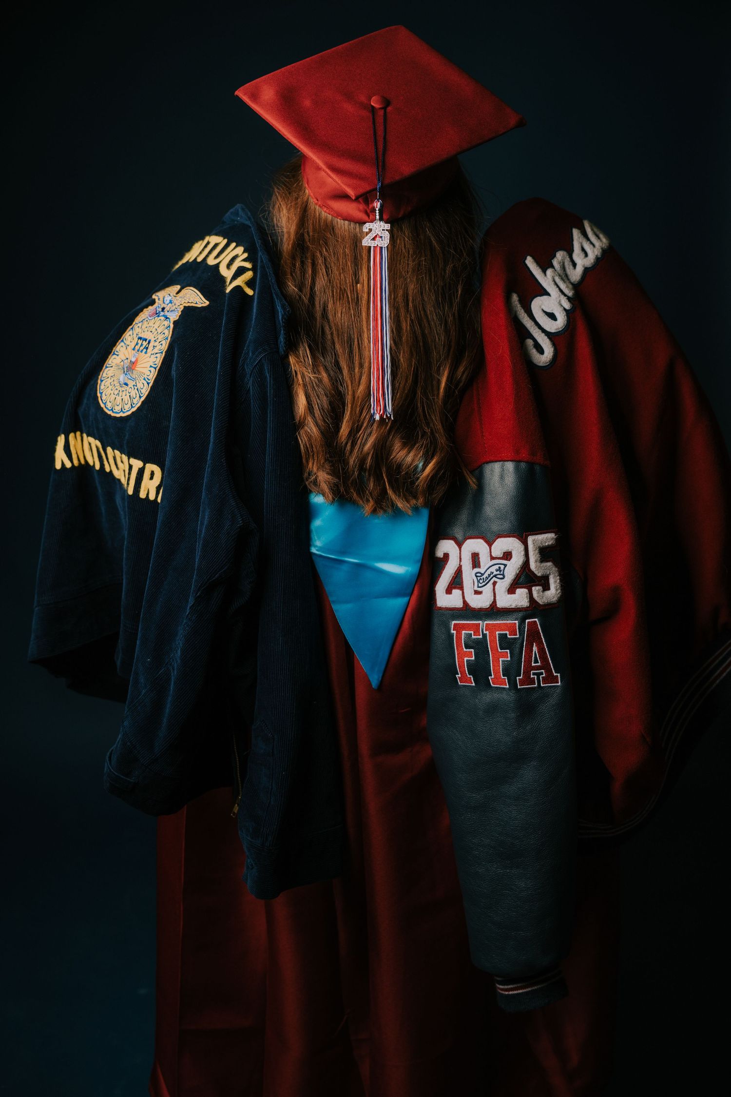 Graduation caps and gowns displayed showing various decorations and club affiliations like FFA.