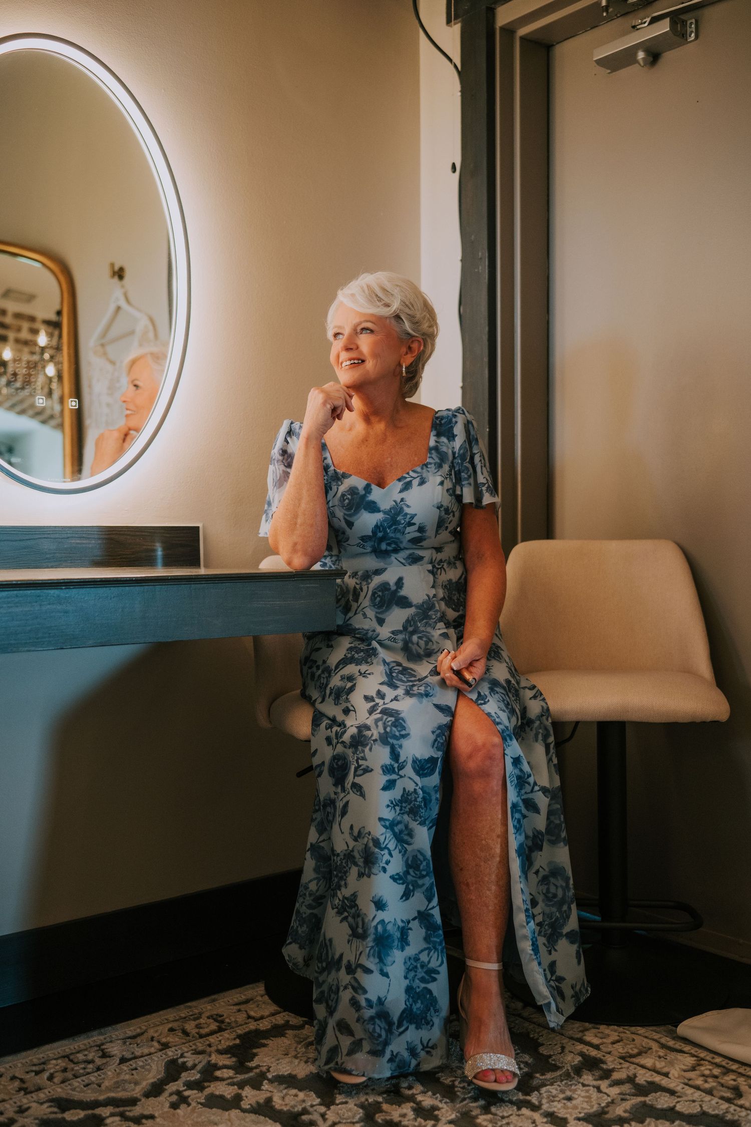 Getting ready moments captured in elegant dressing room with circular mirrors.