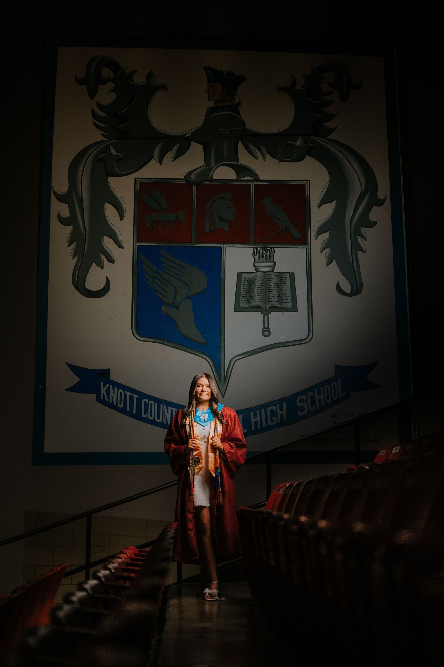 Dark interior hallway with school crest and banner visible on wall.