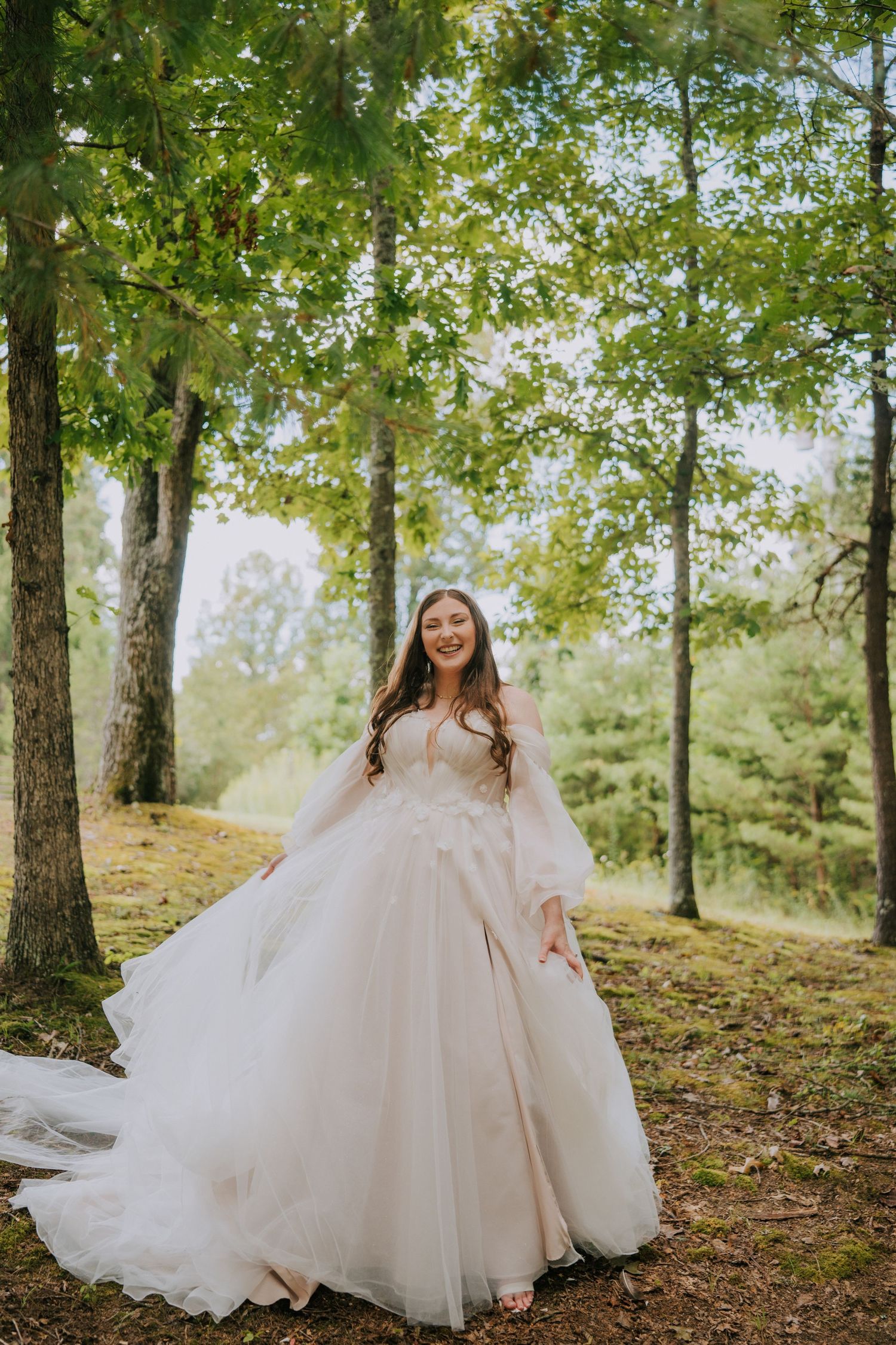 Flowing white wedding dress twirls gracefully among trees in a sunlit forest.