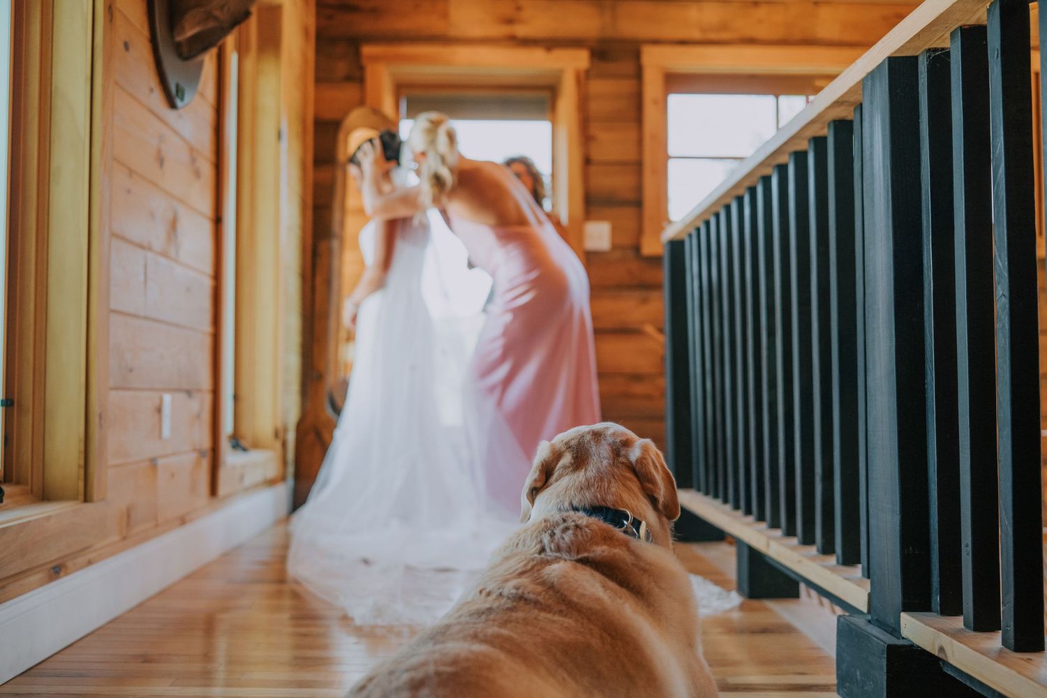 Wedding party walking through rustic wooden venue hallway with natural lighting.