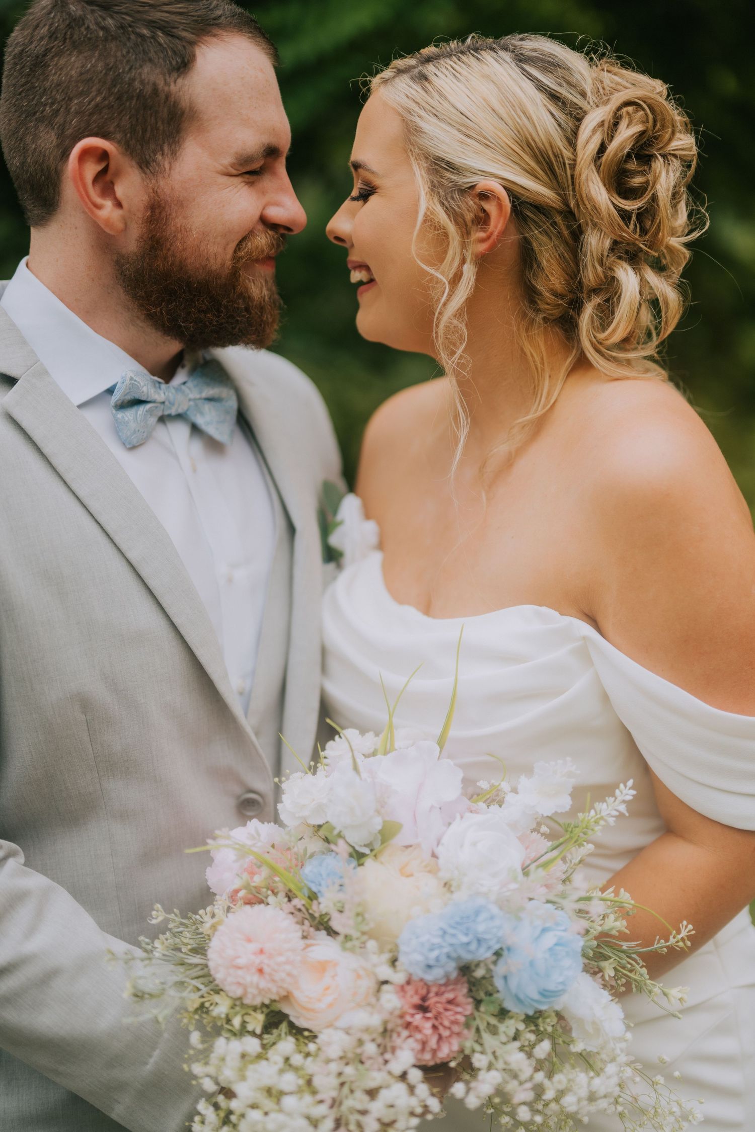Romantic wedding portraits featuring soft pastel bouquets and elegant attire.
