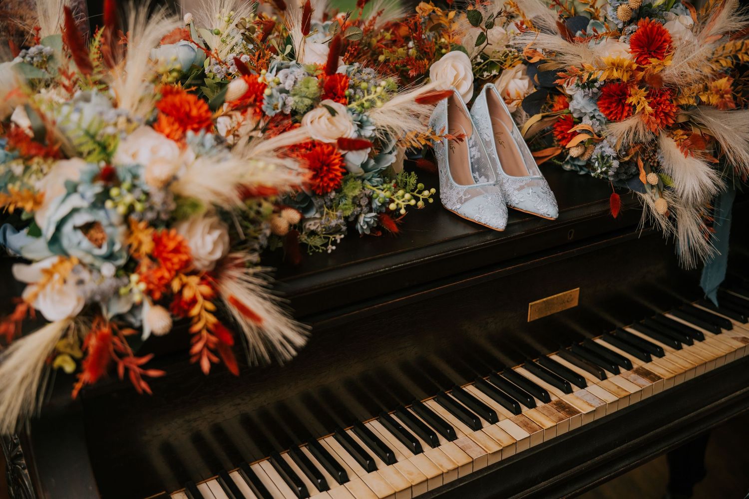 Colorful floral arrangements with red and pink blooms decorating a piano keyboard.