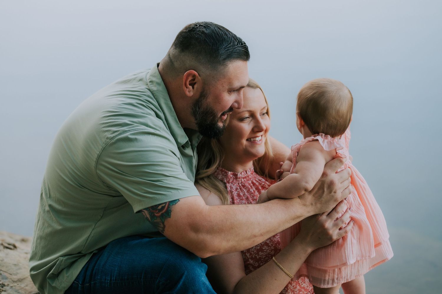 Intimate family moments captured in soft natural lighting against a misty background.