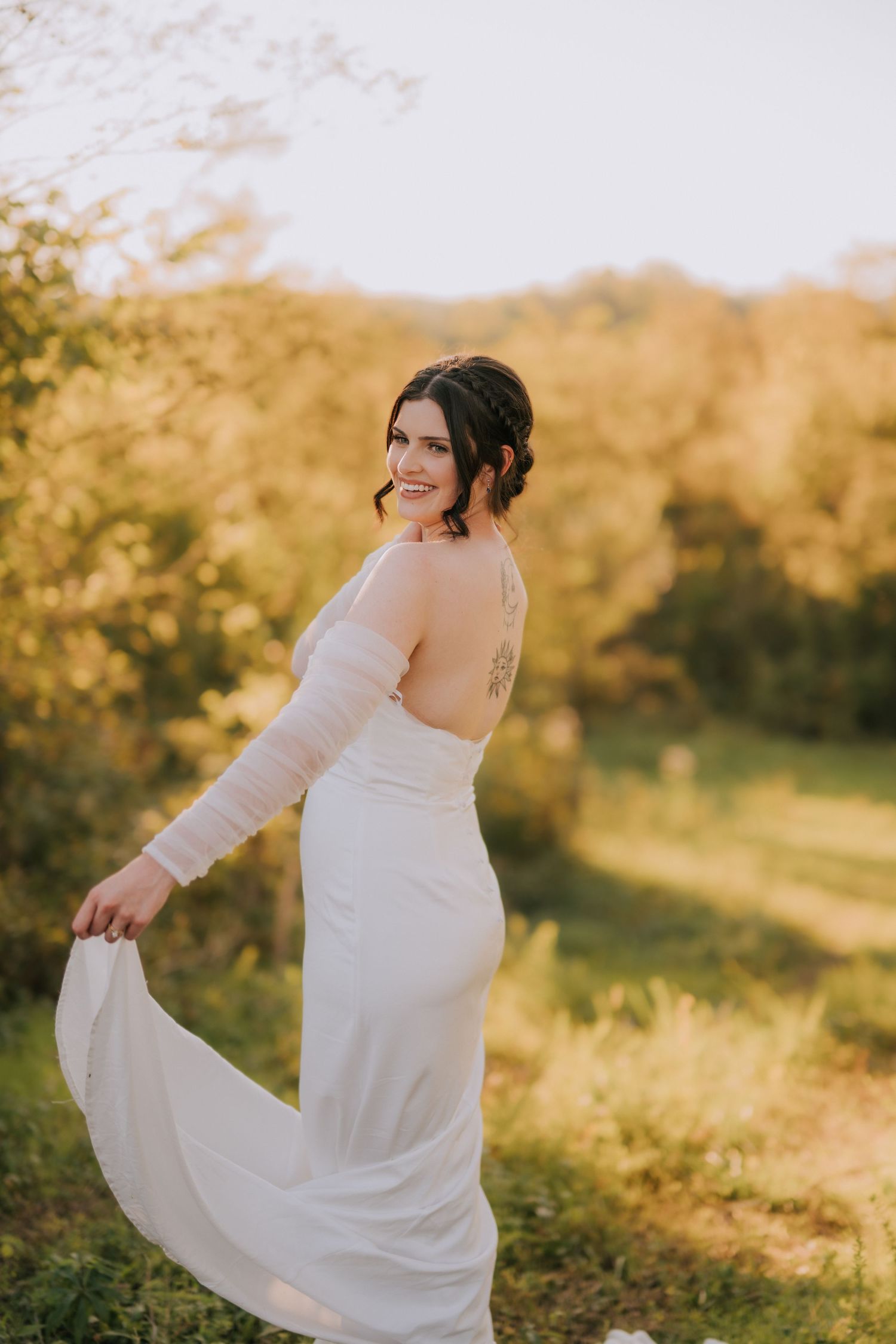 Elegant white wedding dress flowing in the breeze during an outdoor photoshoot.