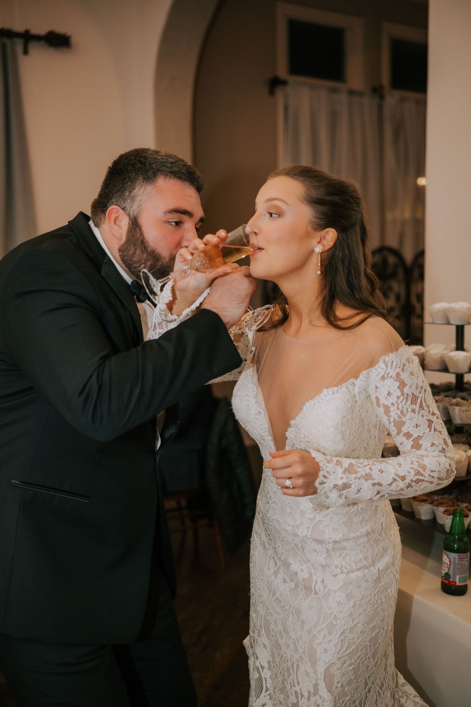 Couple playfully feeds each other wedding cake during their reception celebration.