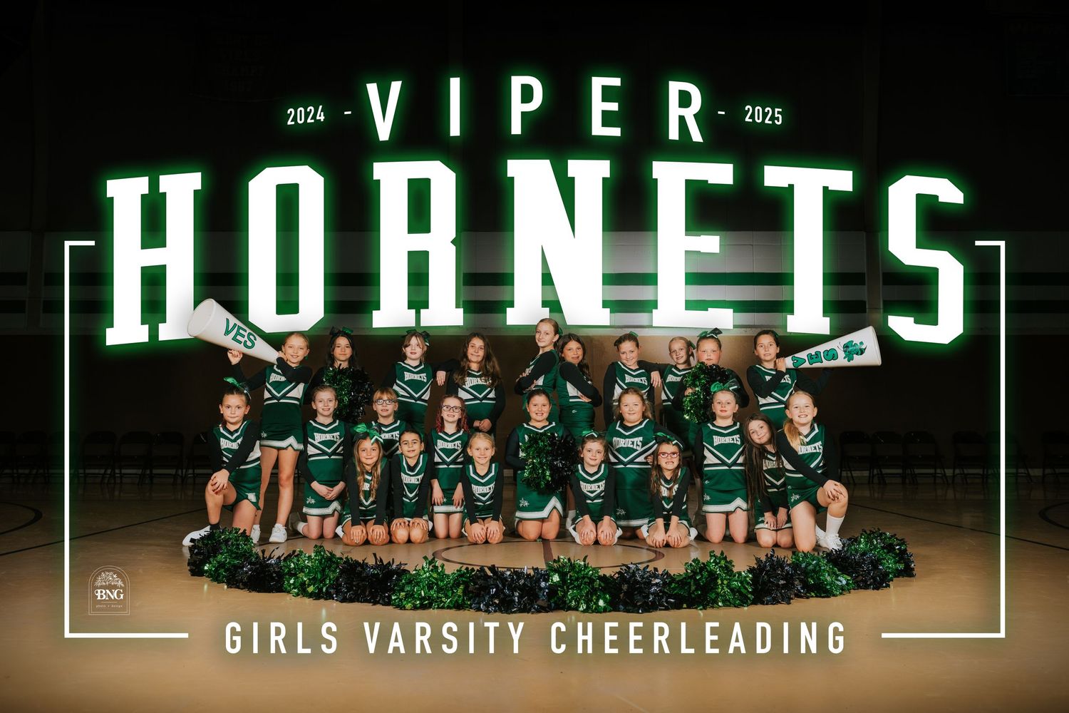 Group photo of cheerleaders in matching green and white uniforms posing on a gym floor with a scoreboard visible.
