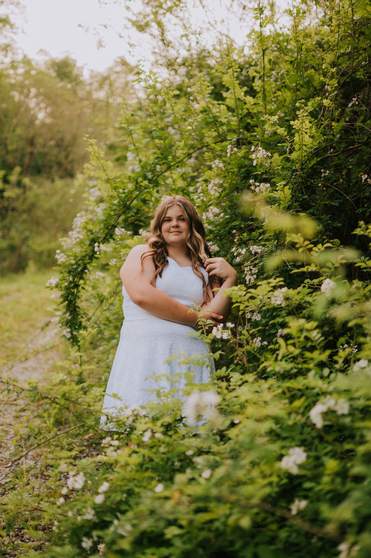 A light blue dress stands out against lush green foliage in a summer garden setting.