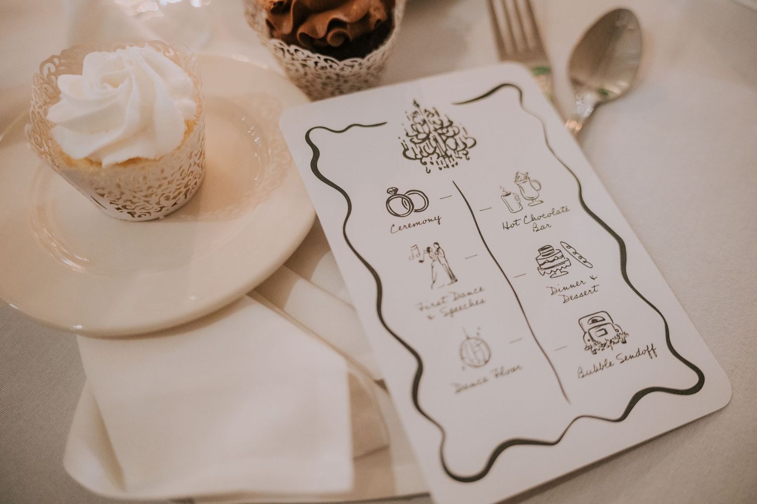 Elegant wedding invitations with decorative borders displayed on a white tablecloth.