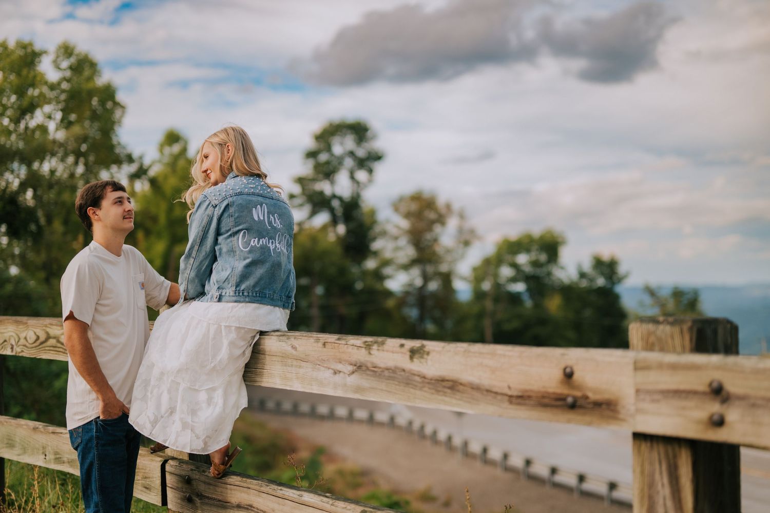 Scenic outdoor boardwalk overlooking natural landscape under cloudy skies.