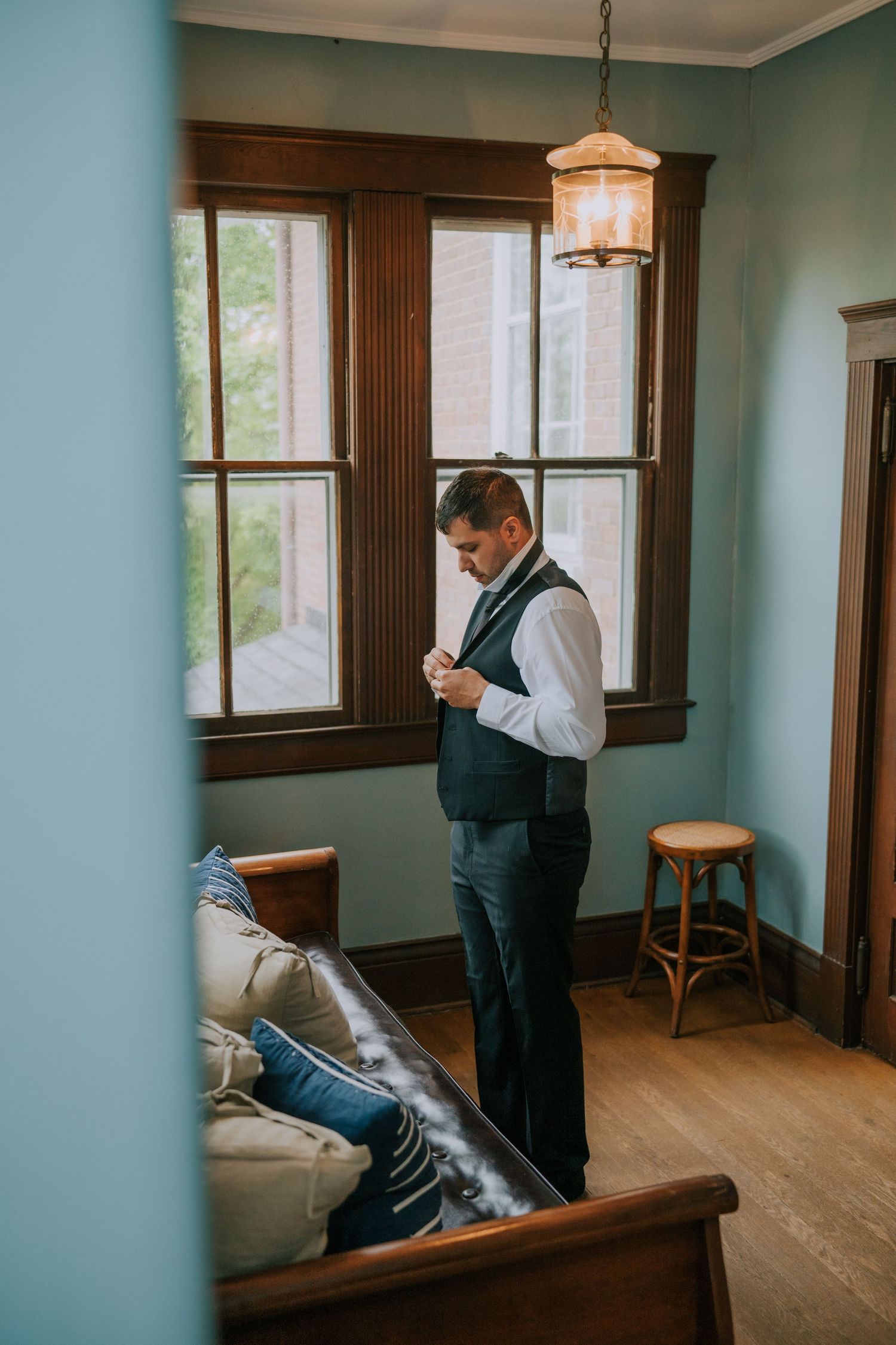 Getting ready scenes in a blue-walled room with wooden trim and natural lighting.