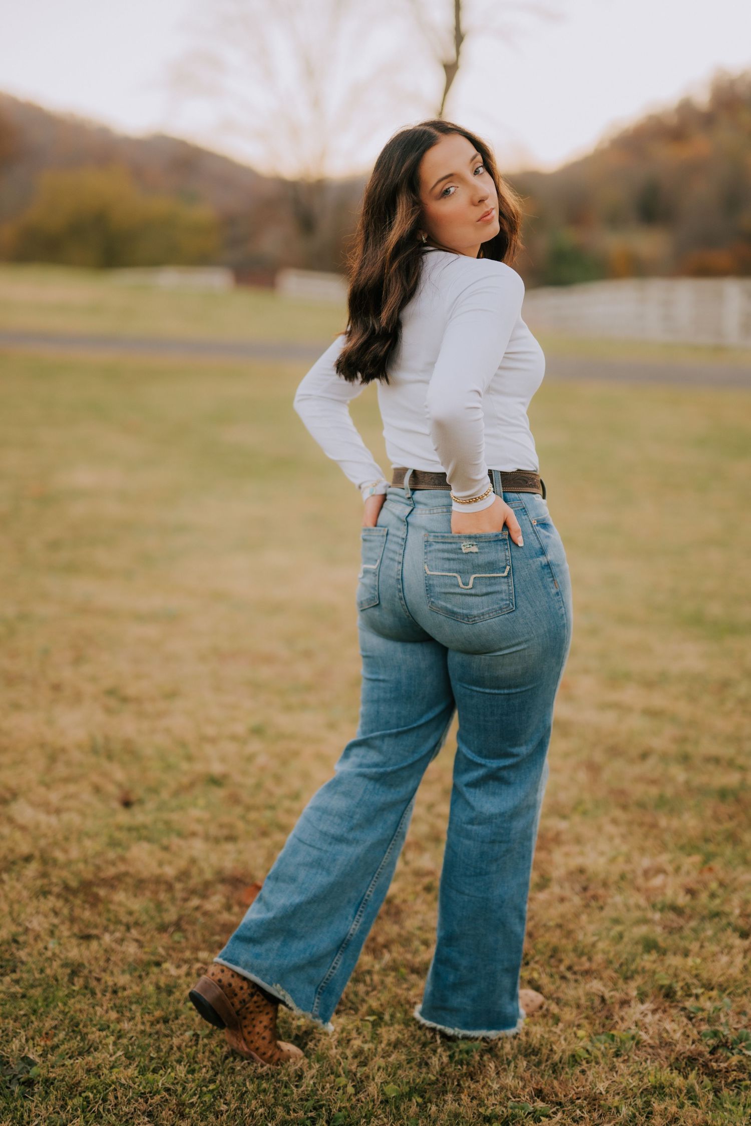 Artistic fashion shots showing denim jeans and white top in golden field setting.