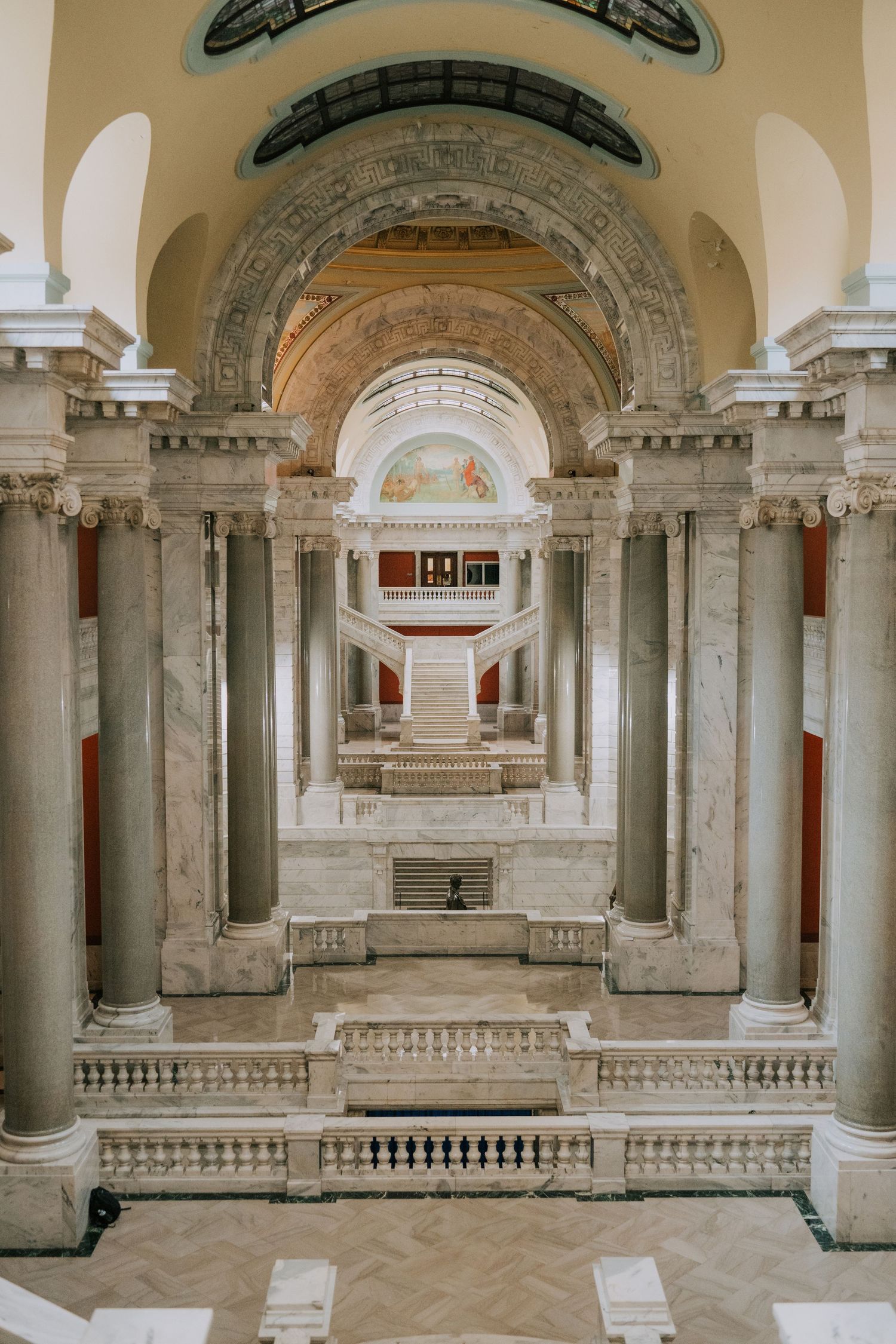 Ornate marble interior of a historic building with grand arches, columns and decorative architectural details.