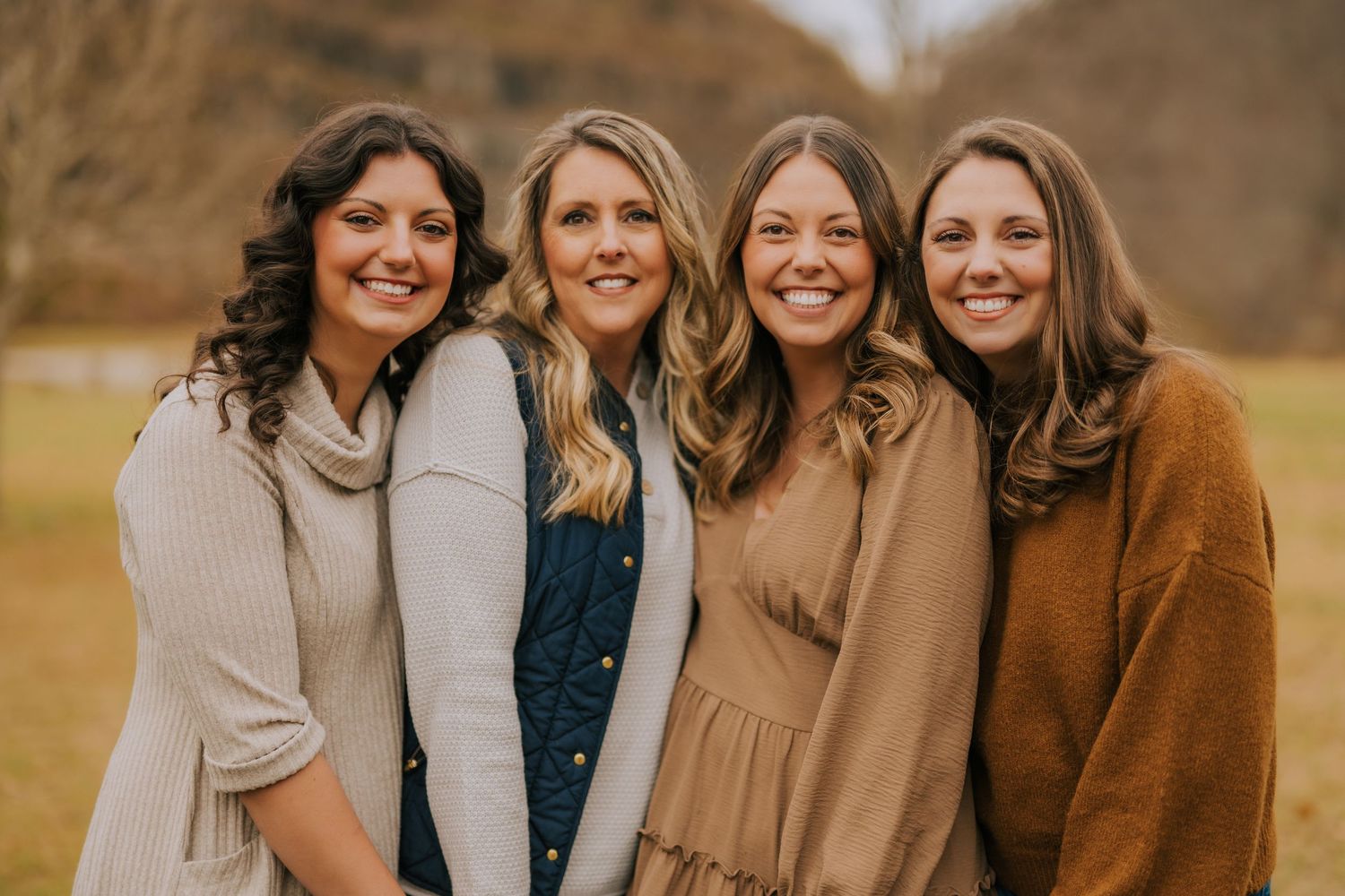 A group photo showing people wearing coordinated earth-toned outfits in an outdoor autumn setting.