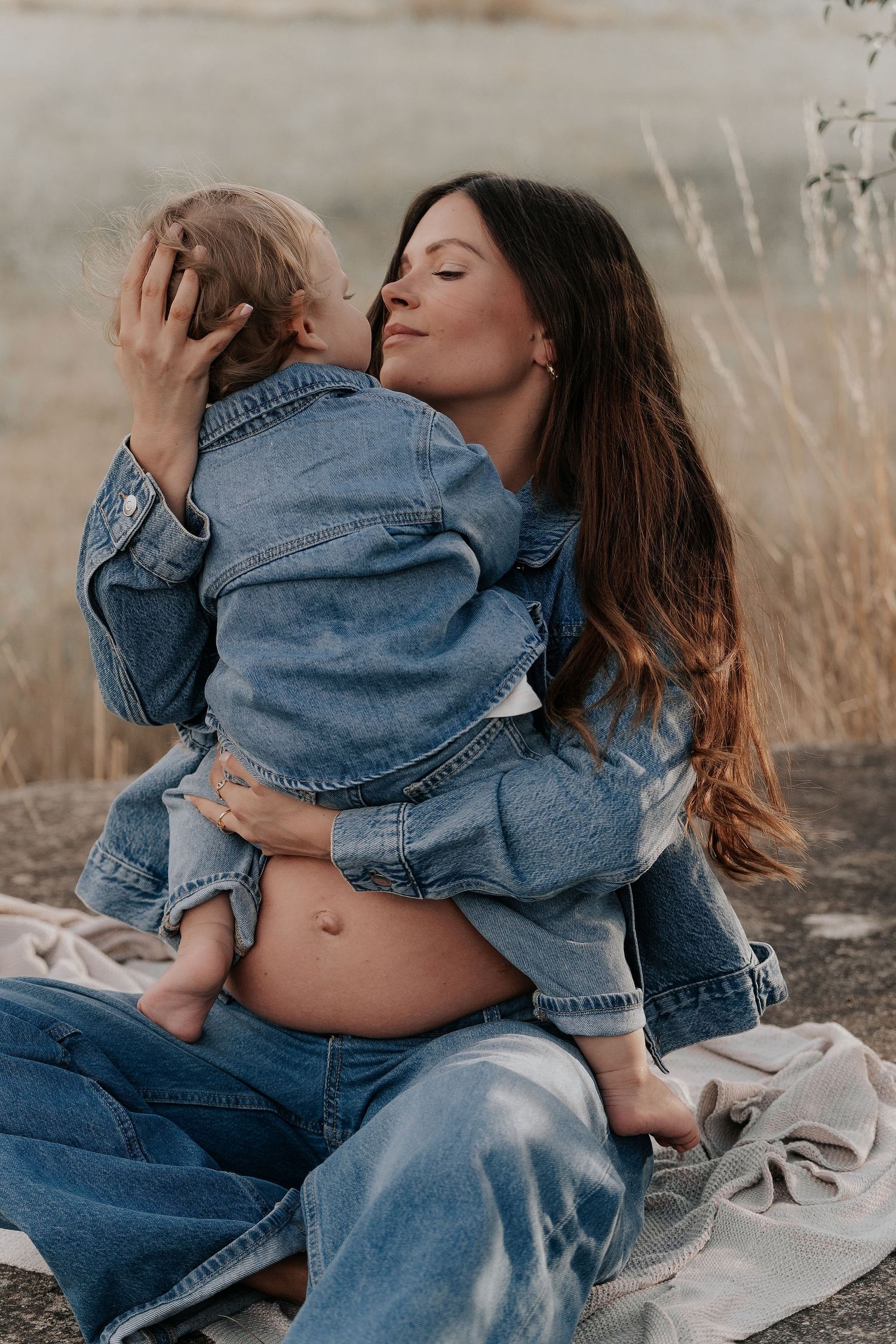 Mother and child in denim sharing intimate moments outdoors.