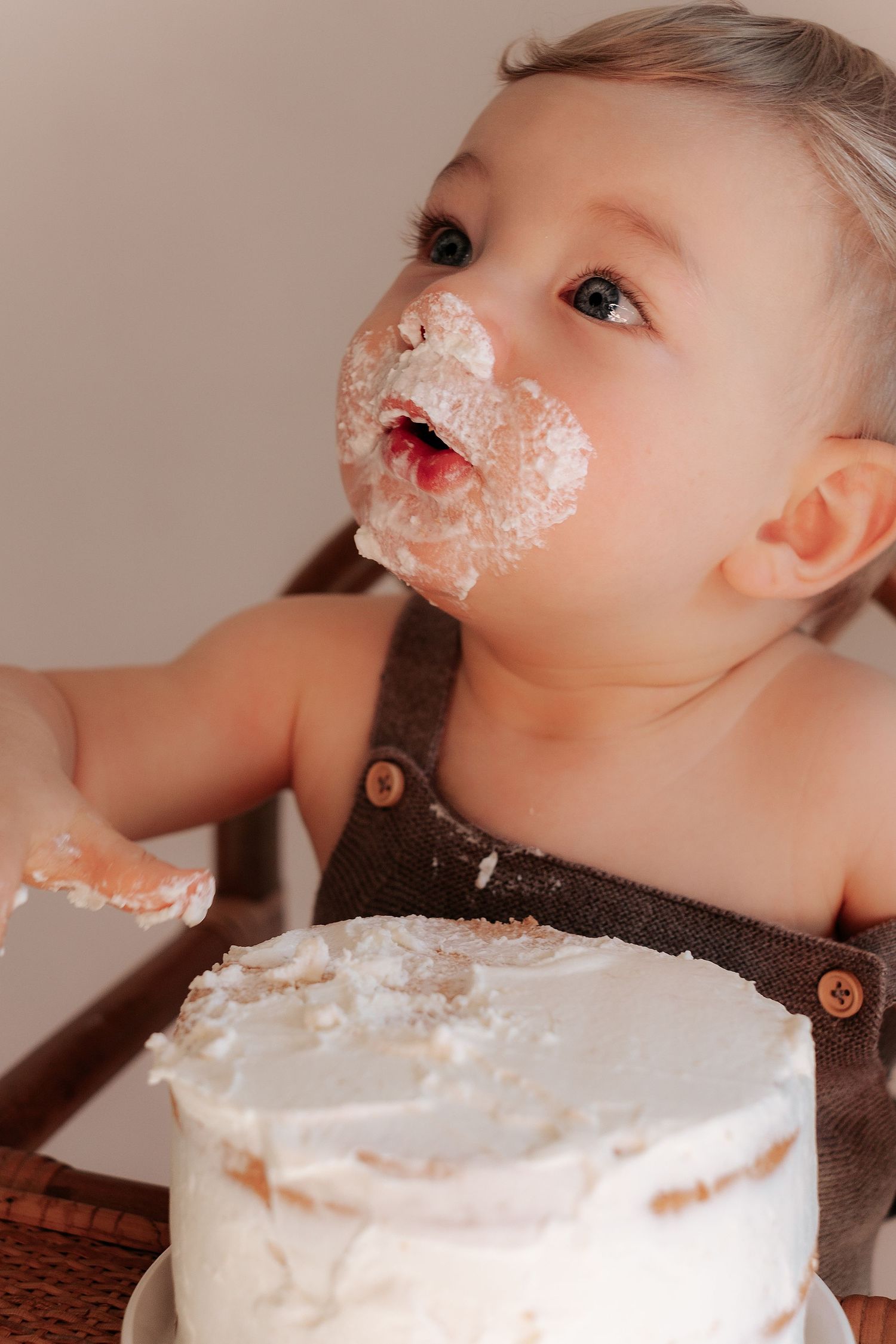 Sequence showing messy white frosting around a small child's mouth while eating cake.