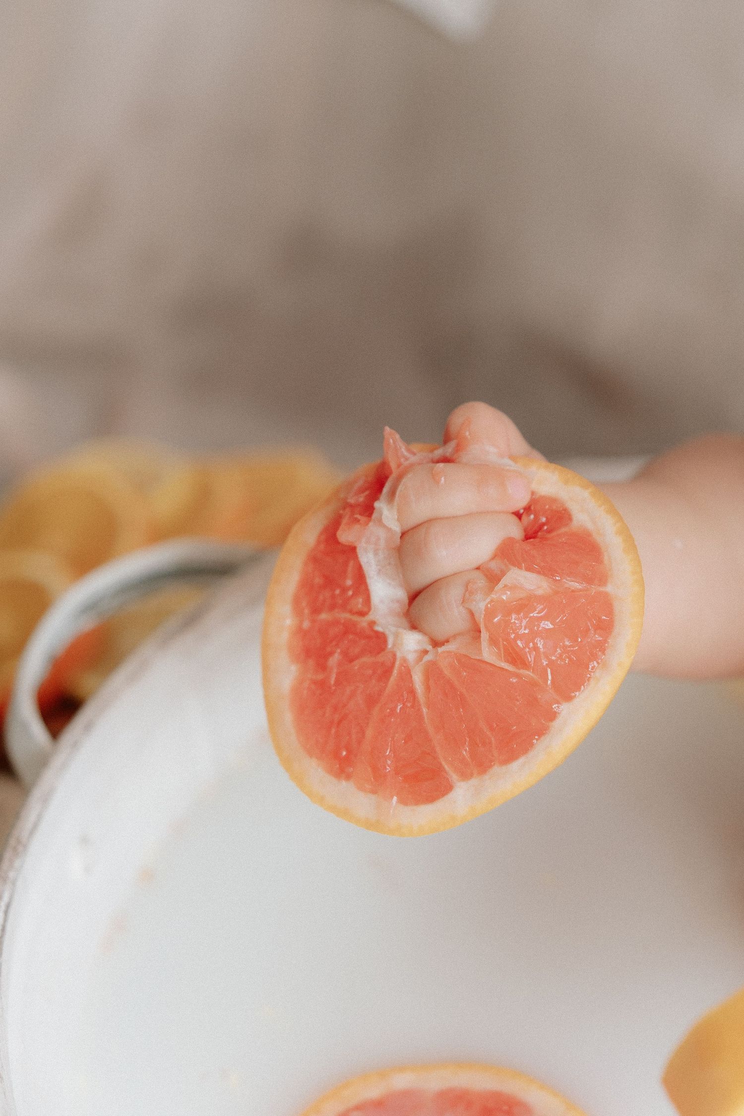 Sliced pink grapefruit segments arranged in a row showing the juicy citrus flesh.