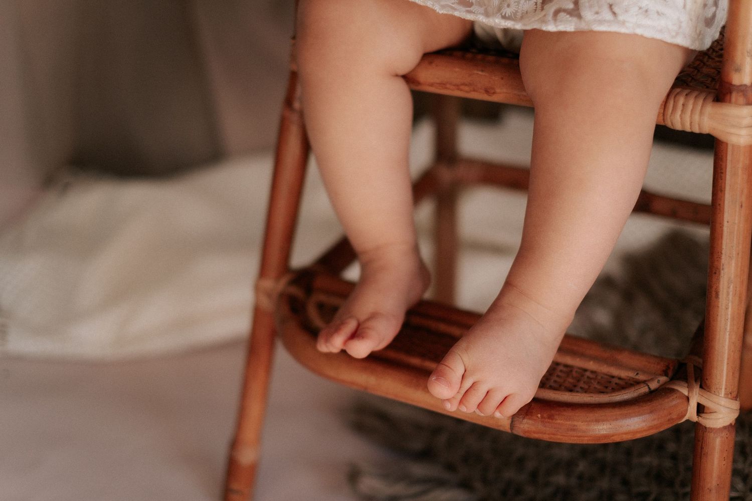 Little bare feet dangling from a wooden chair.