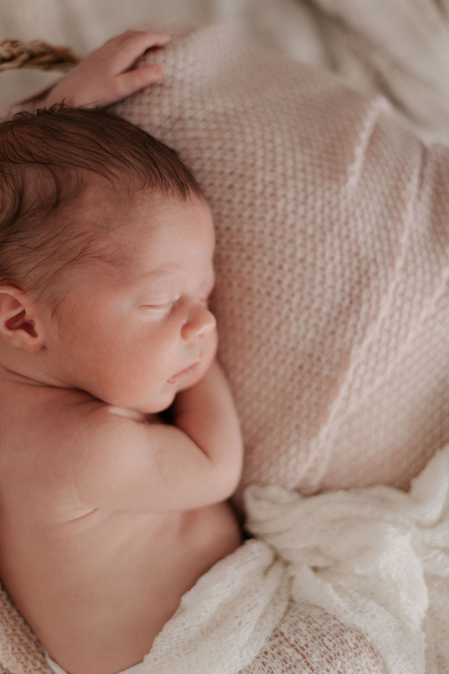 A sleeping newborn baby wrapped in soft white knit blanket shown from different angles in a collage.