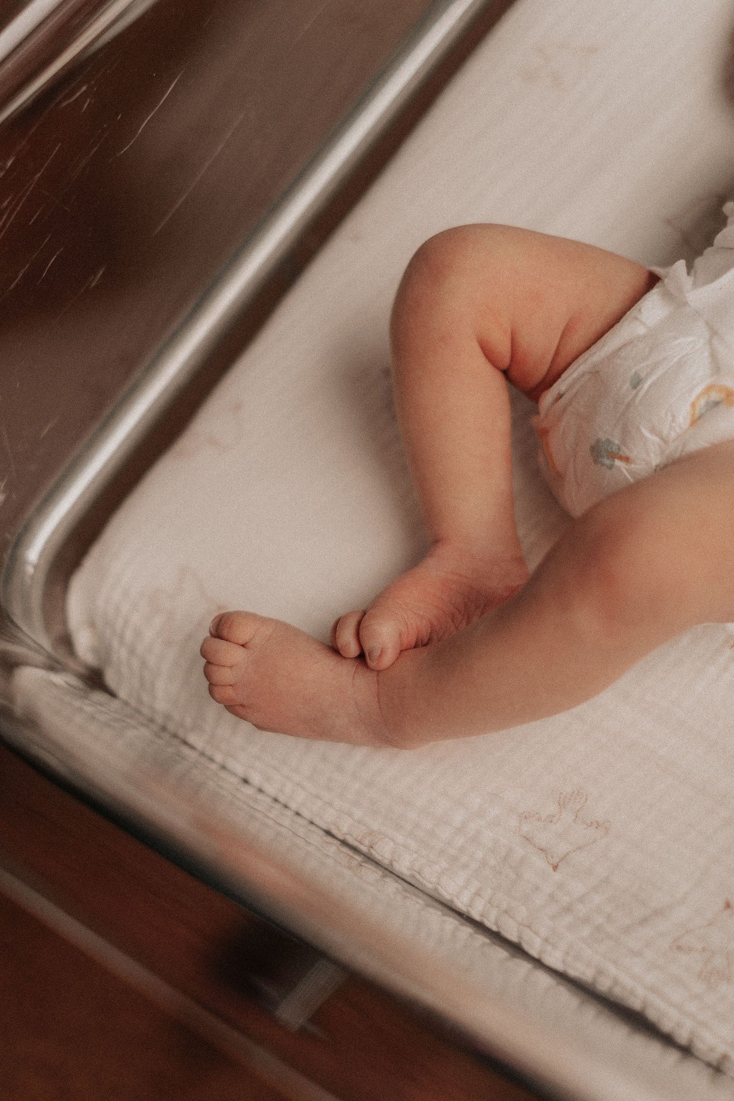 Small bare feet resting on a white textured blanket.