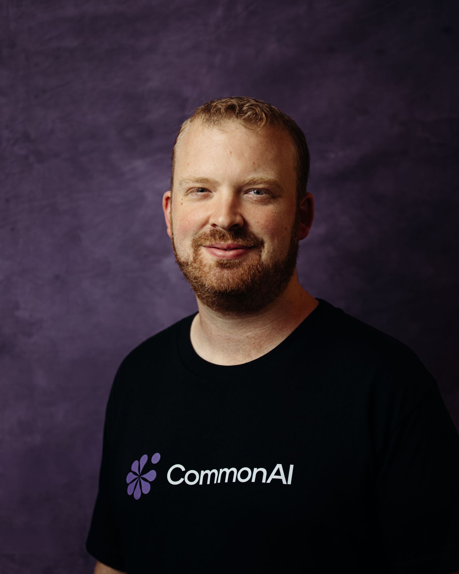 Portrait series showing different angles in black t-shirt against dark background.