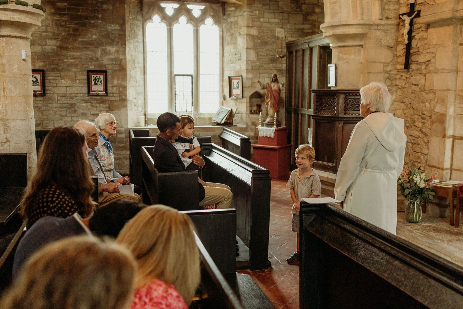 Interior of historic stone church with gothic windows and wooden pews.