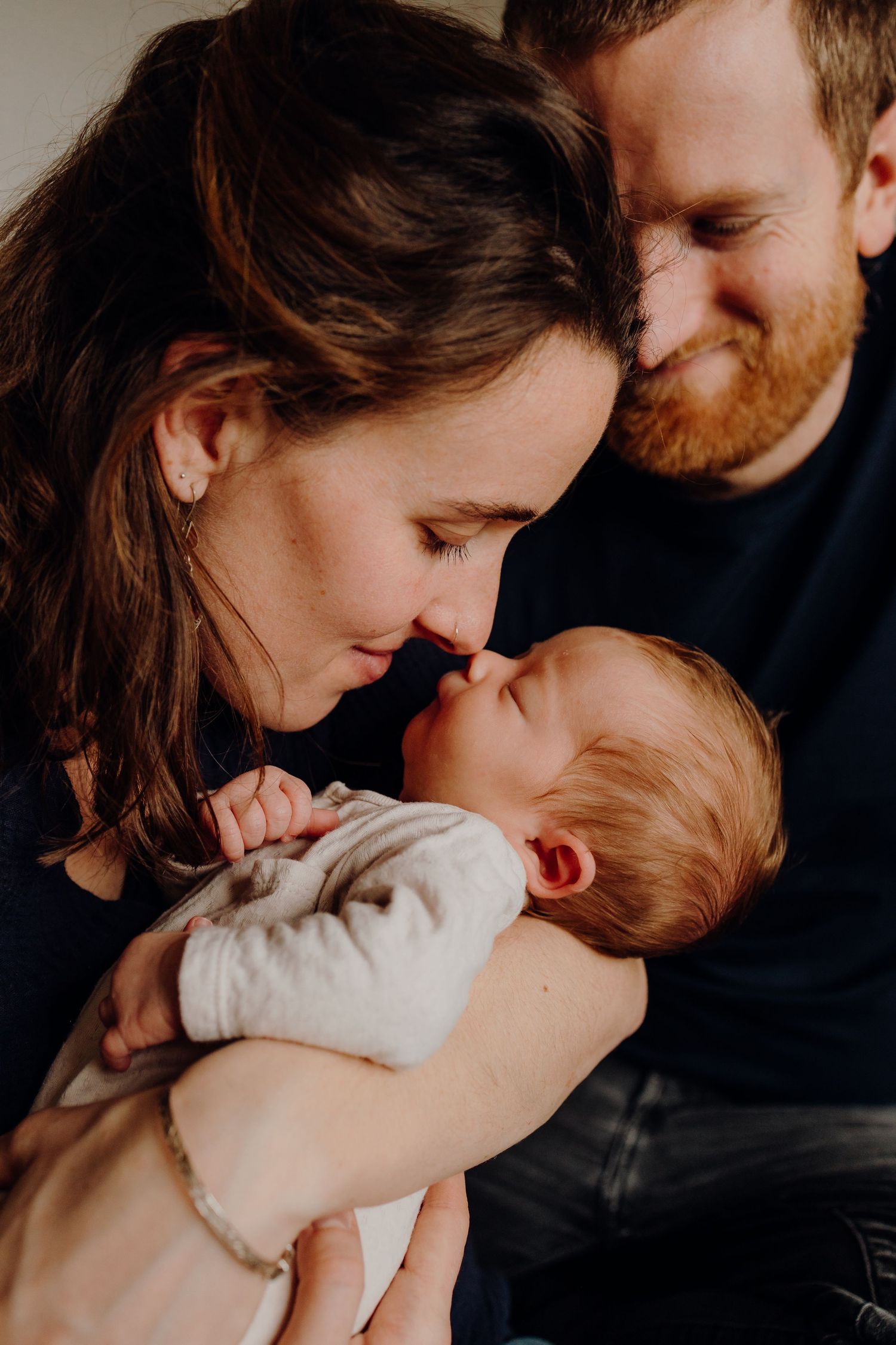 Tender moments with a newborn baby in intimate family portraits.