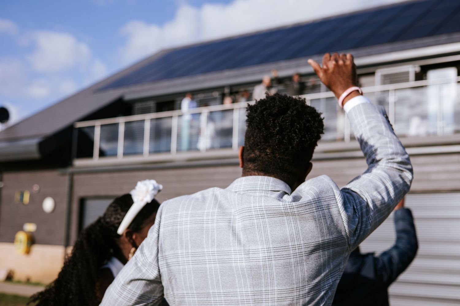 People celebrating outdoors against a backdrop of residential buildings.