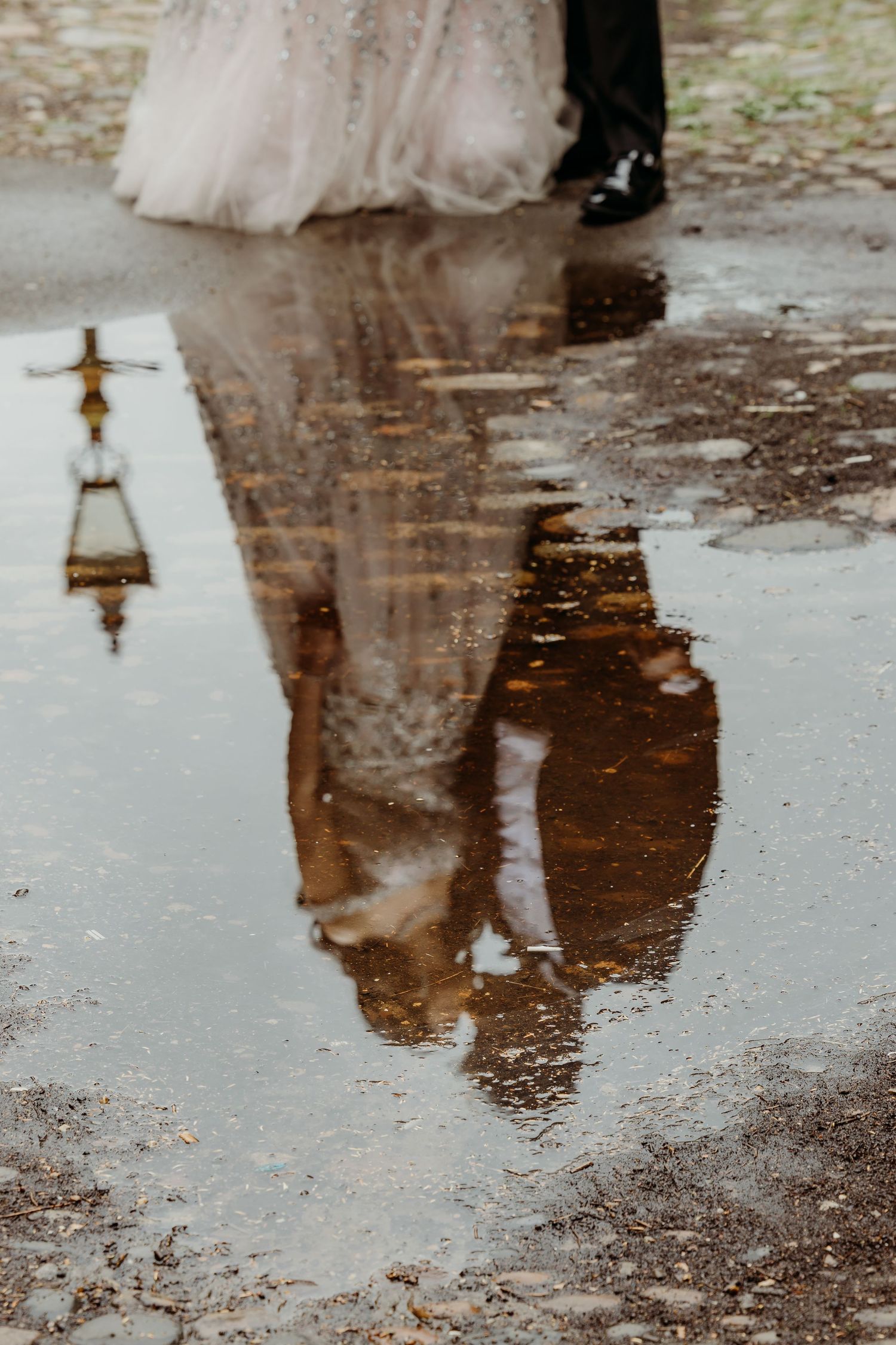 Reflections in puddles on wet pavement creating mirror-like images.