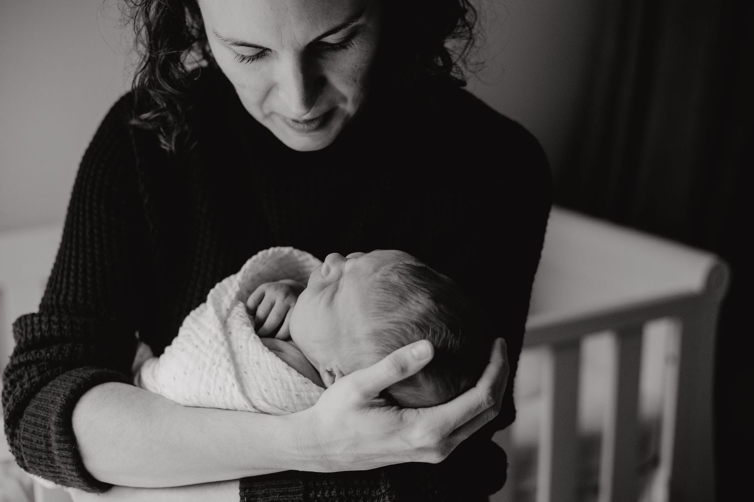 Intimate black and white portraits capturing tender moments between parent and newborn.