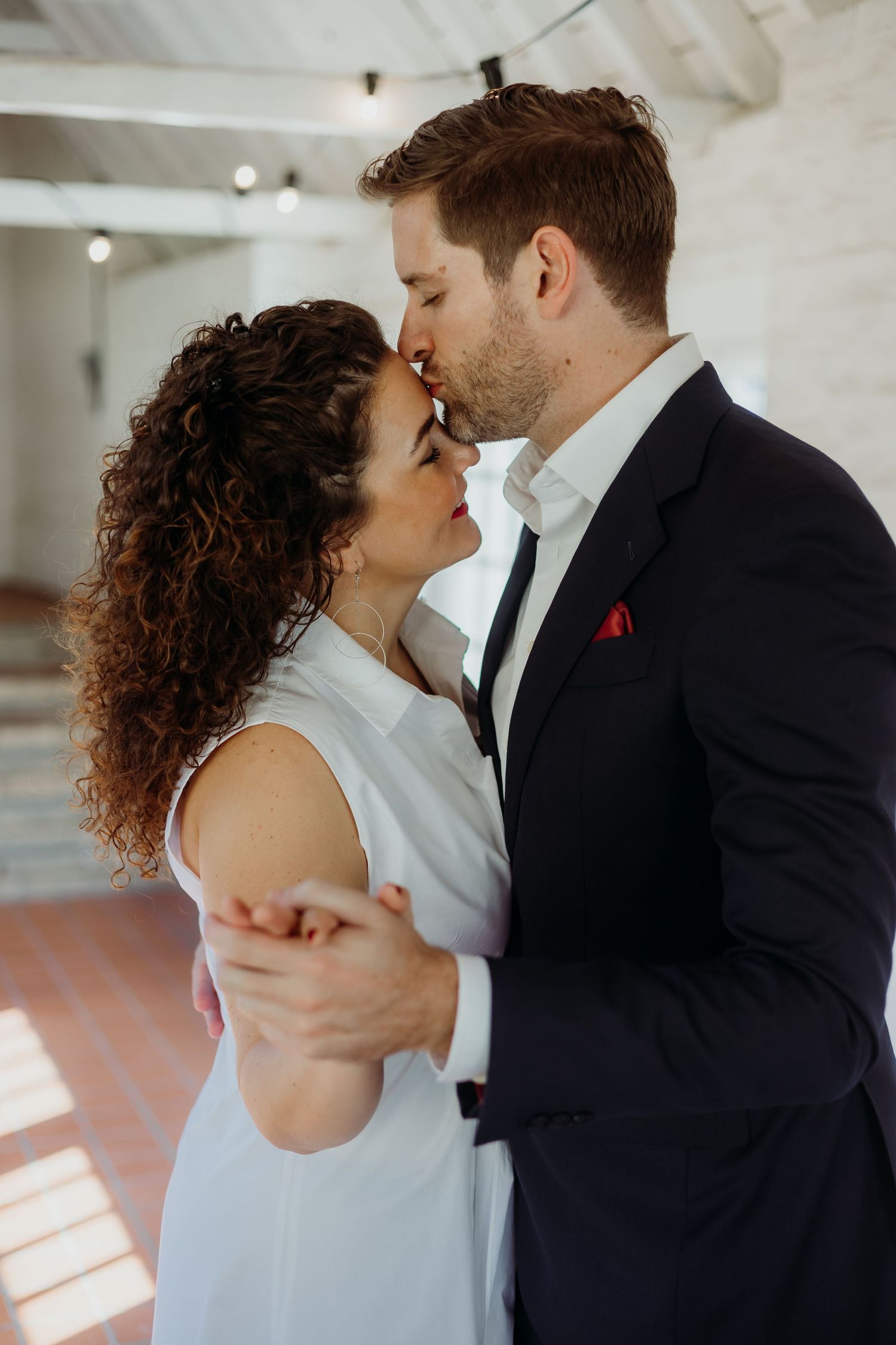Intimate dance moment in bright indoor space with natural lighting.