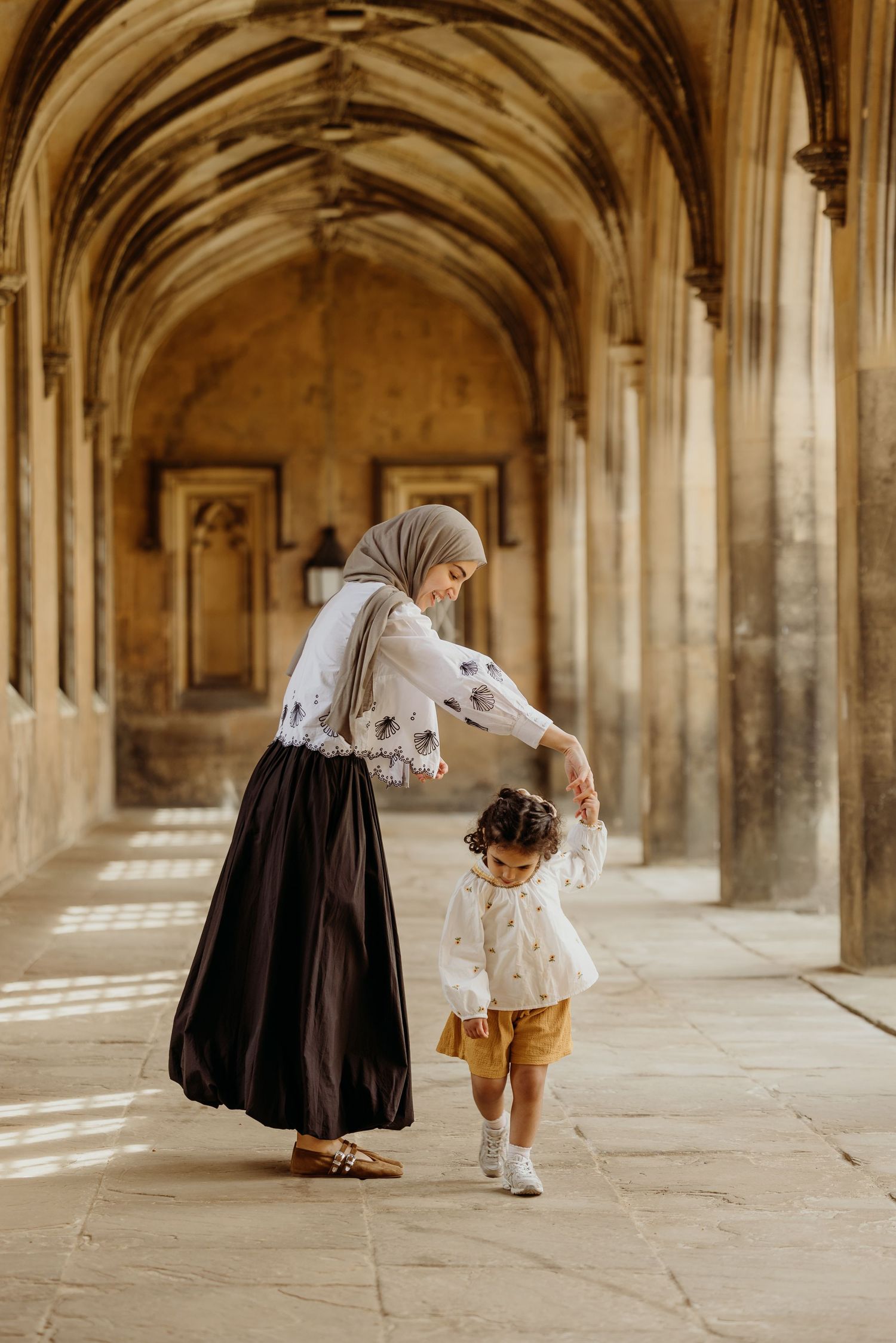 Figures walking through historic stone archways and corridors.