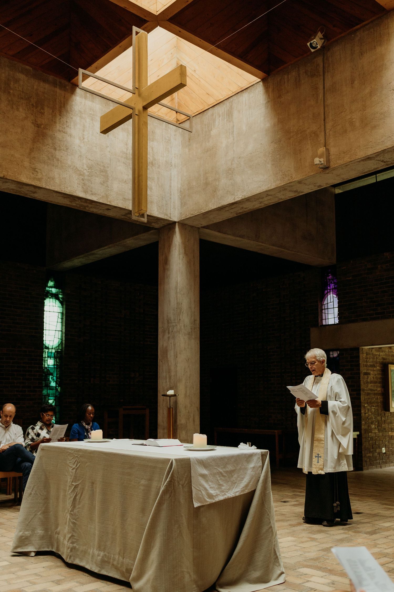 Church interior with white-clothed tables and stained glass windows casting colored light.
