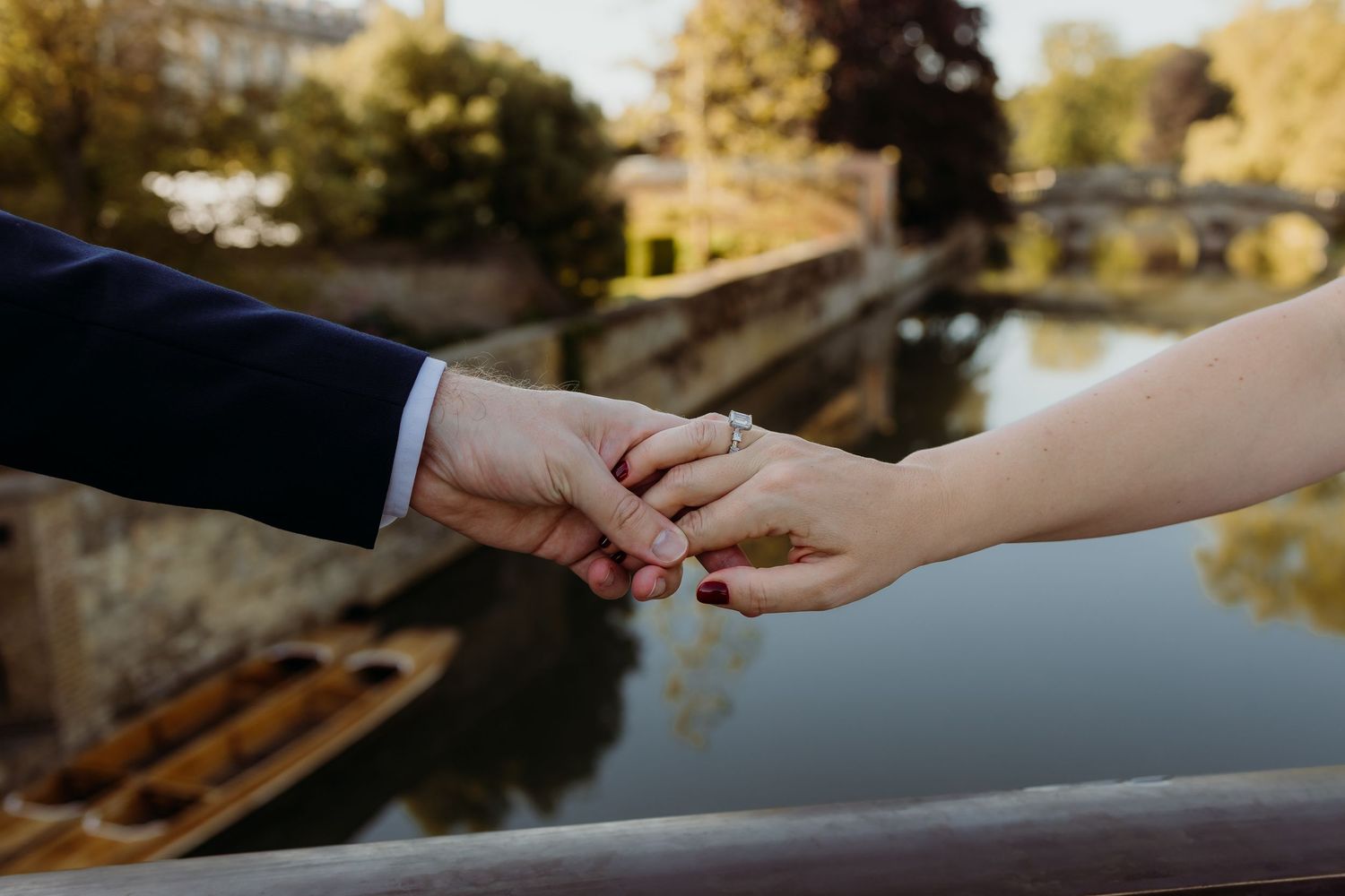 Close-up of hands exchanging rings during golden hour.