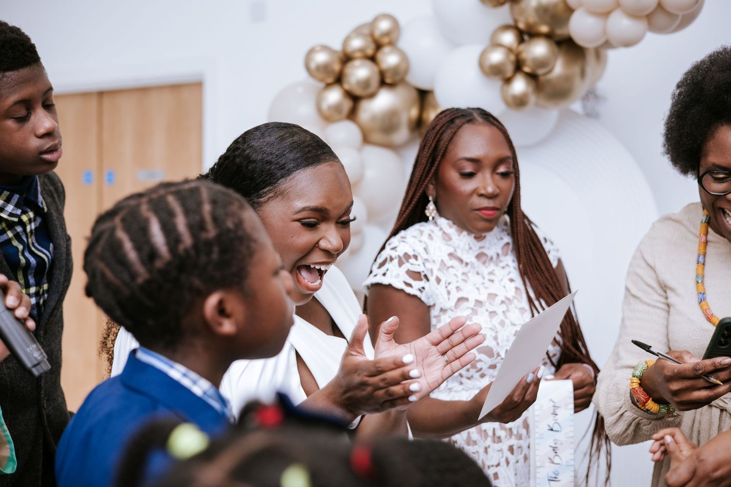 Joyful party guests dancing and celebrating at an elegant white-themed event.