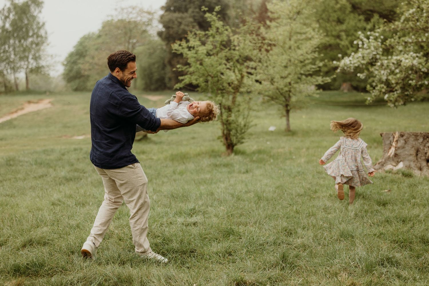 A playful outdoor scene in a grassy field with two people enjoying a game on a misty spring day.