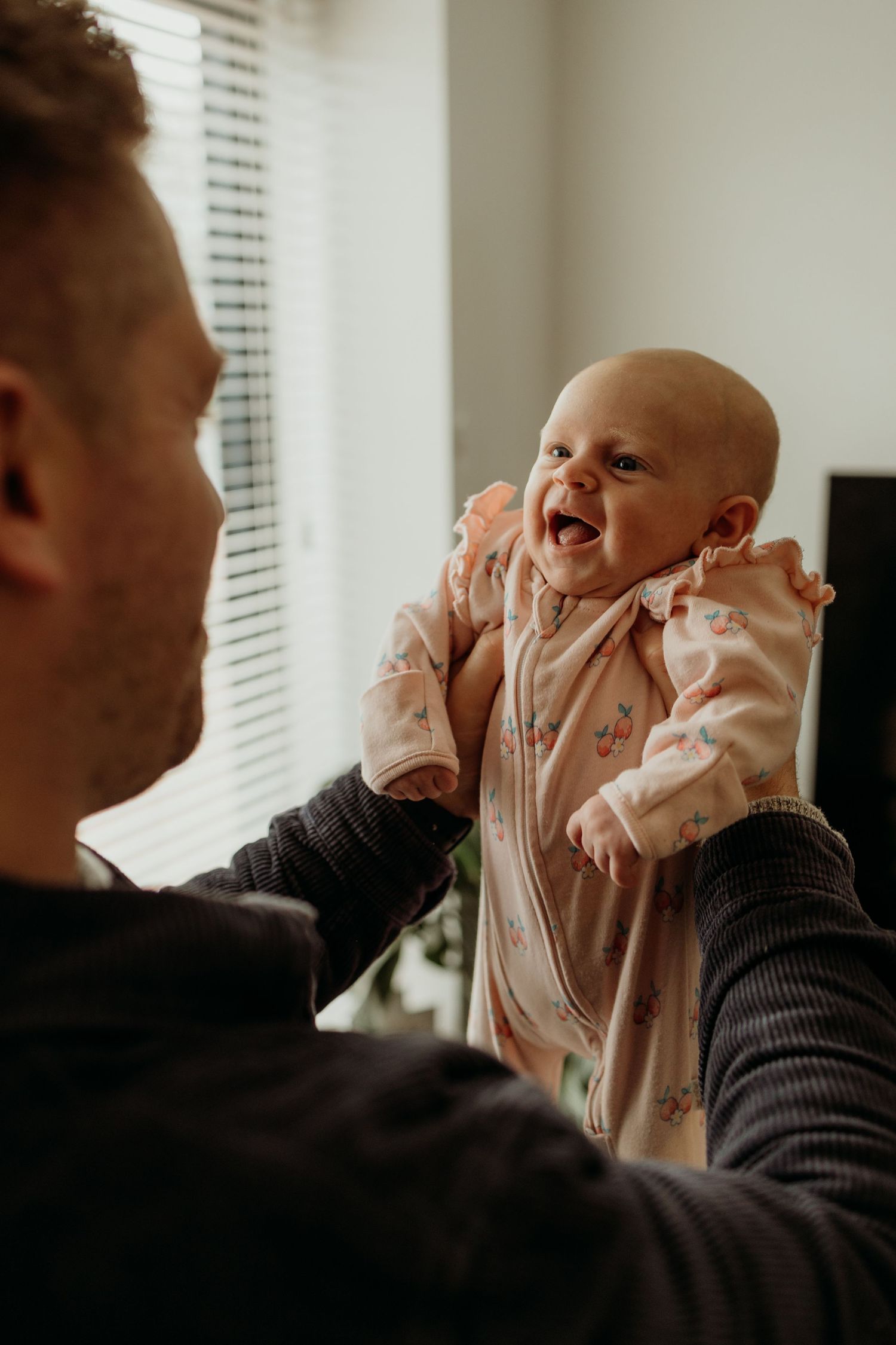 A sequence of photos showing a baby in a pink outfit being lifted and playfully interacting with someone.