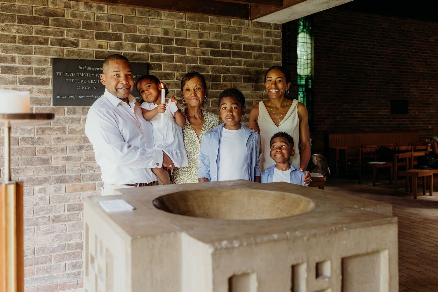 A group gathers around a rustic brick counter in what appears to be a kitchen or dining area.