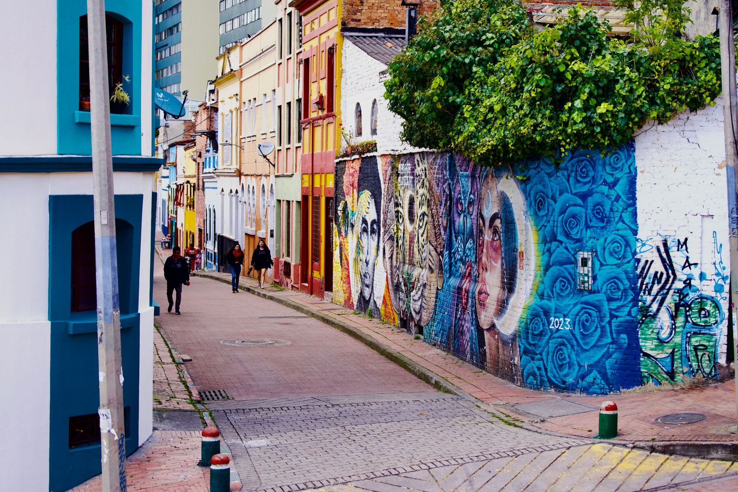 Urban street art and graffiti decorating walls along a curved pedestrian path.