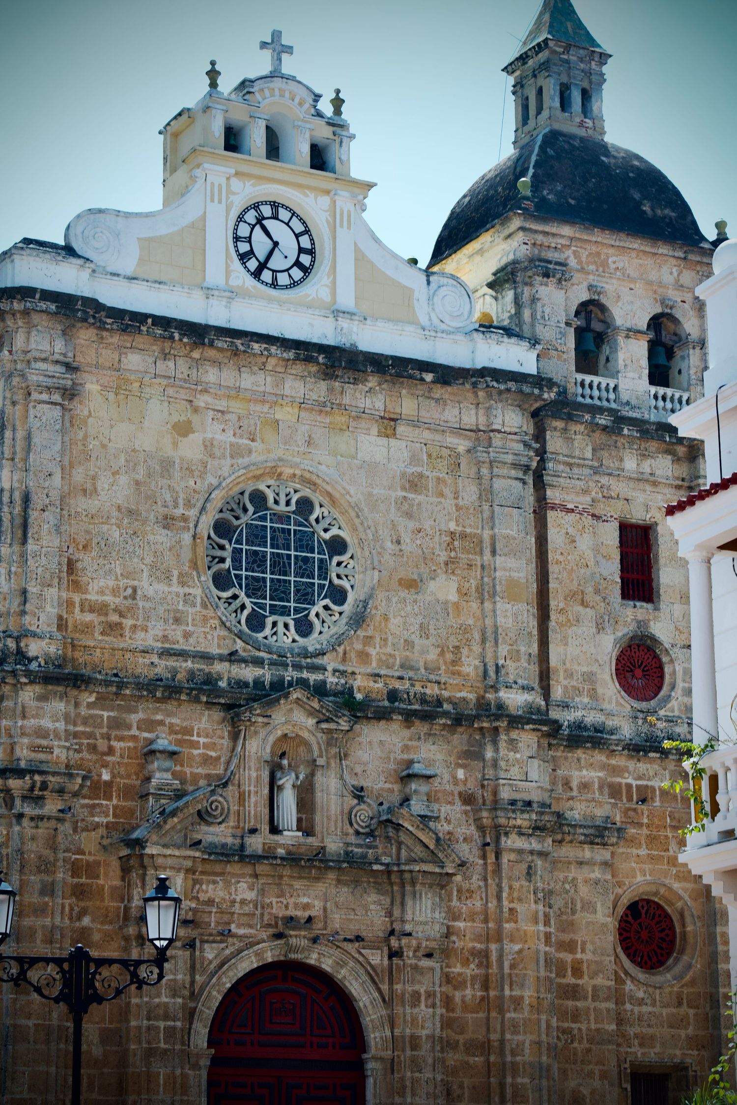 Historic stone church facade with ornate architecture and cross details in colonial style.
