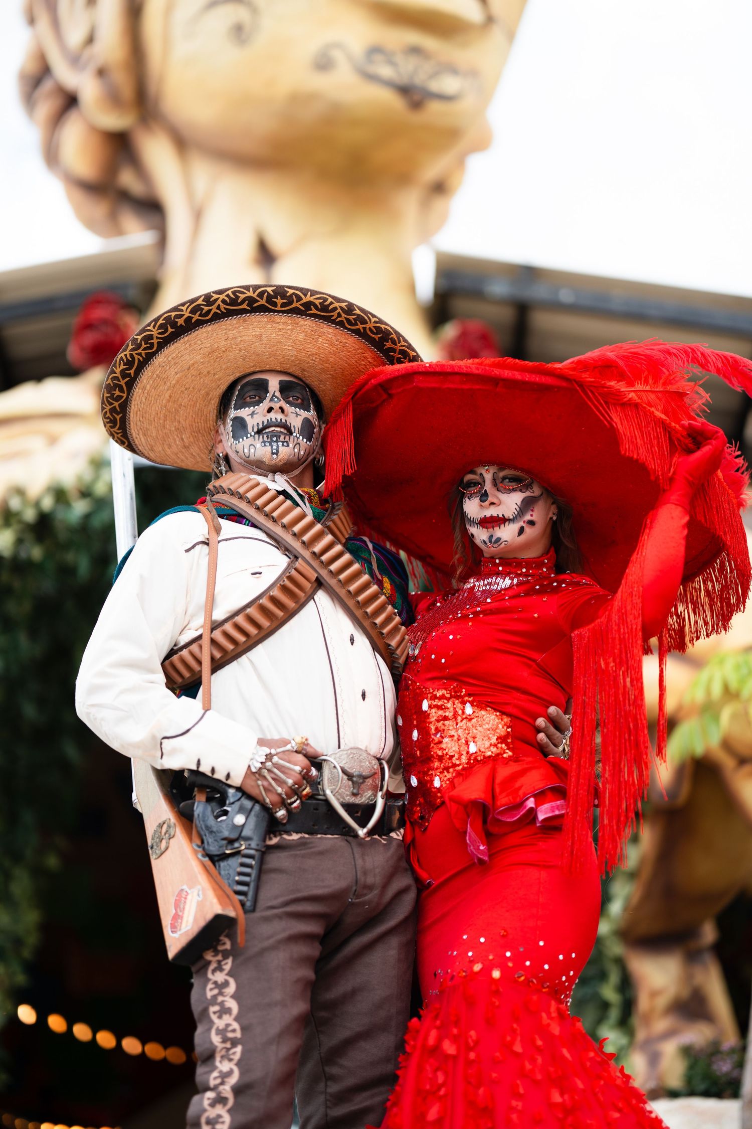 Two decorative Day of the Dead skeleton figures dressed in traditional Mexican attire with sombreros and bright colors.