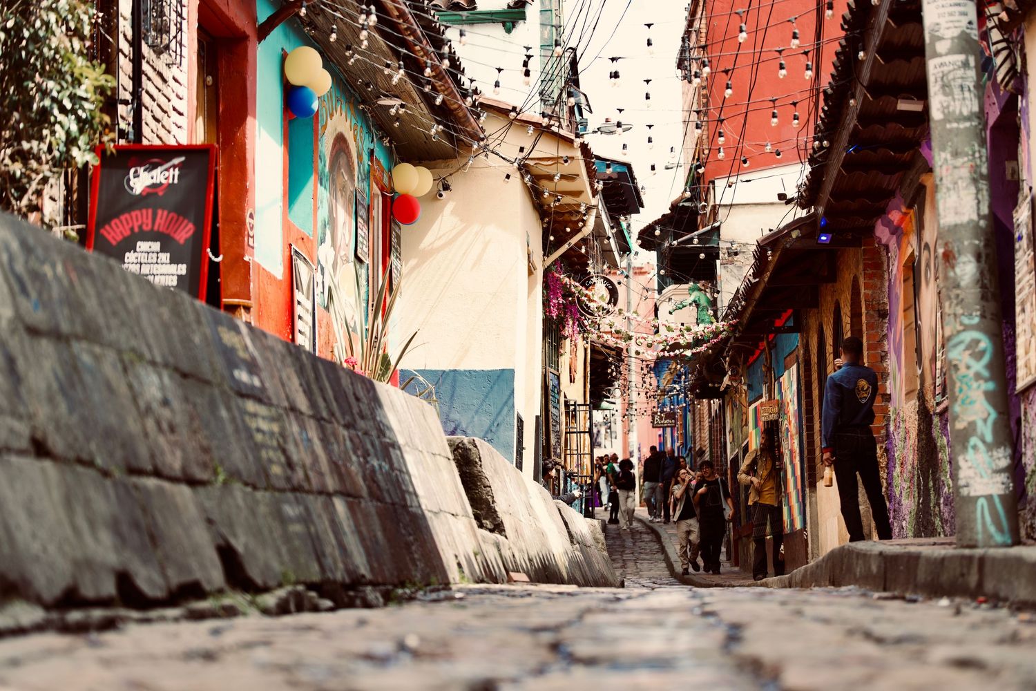 Colorful narrow alleyway with red walls and hanging decorations in a historic district.