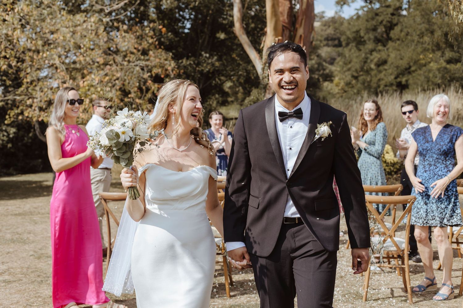bride and groom laughing with joy as they walk back up the aisle