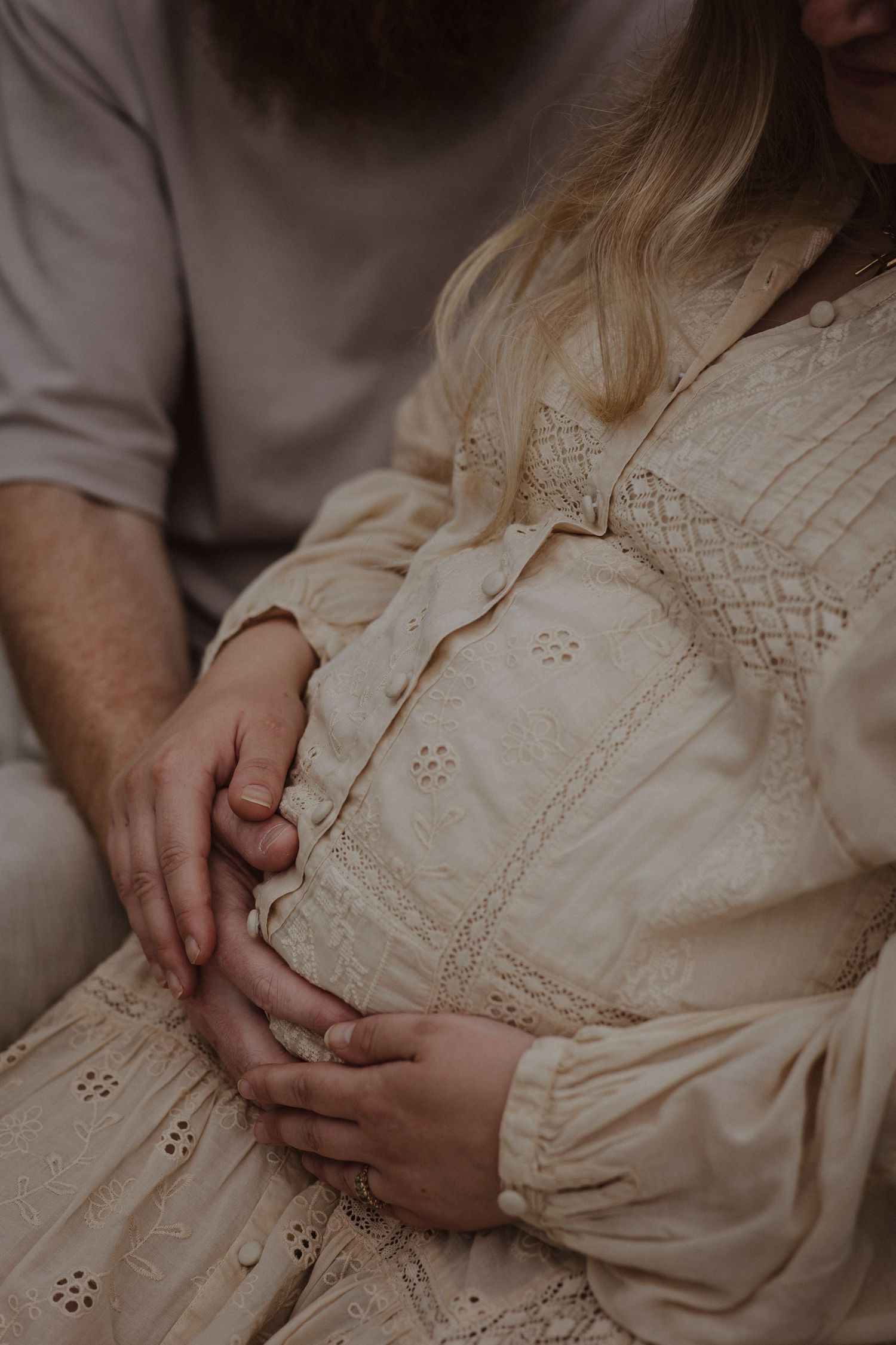 mother and father holding onto the mothers pregnancy belly