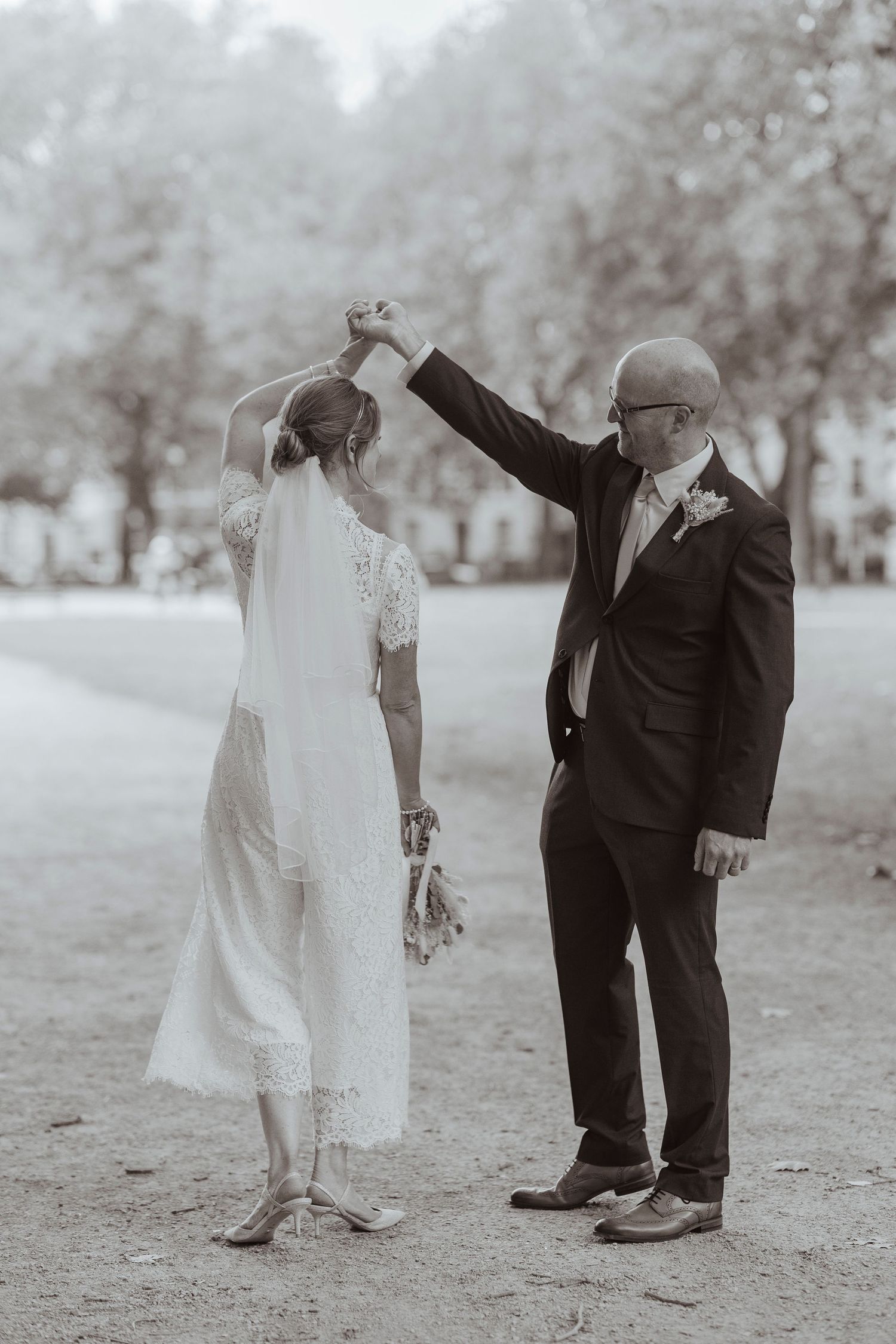 bride and groom dancing in the park