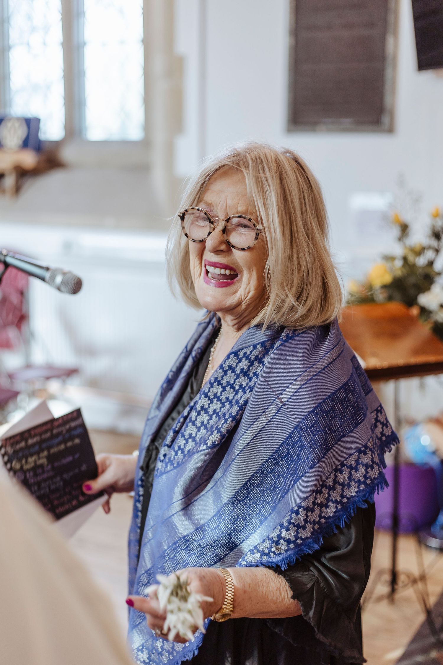 woman smiling proudly whilst reading at a service