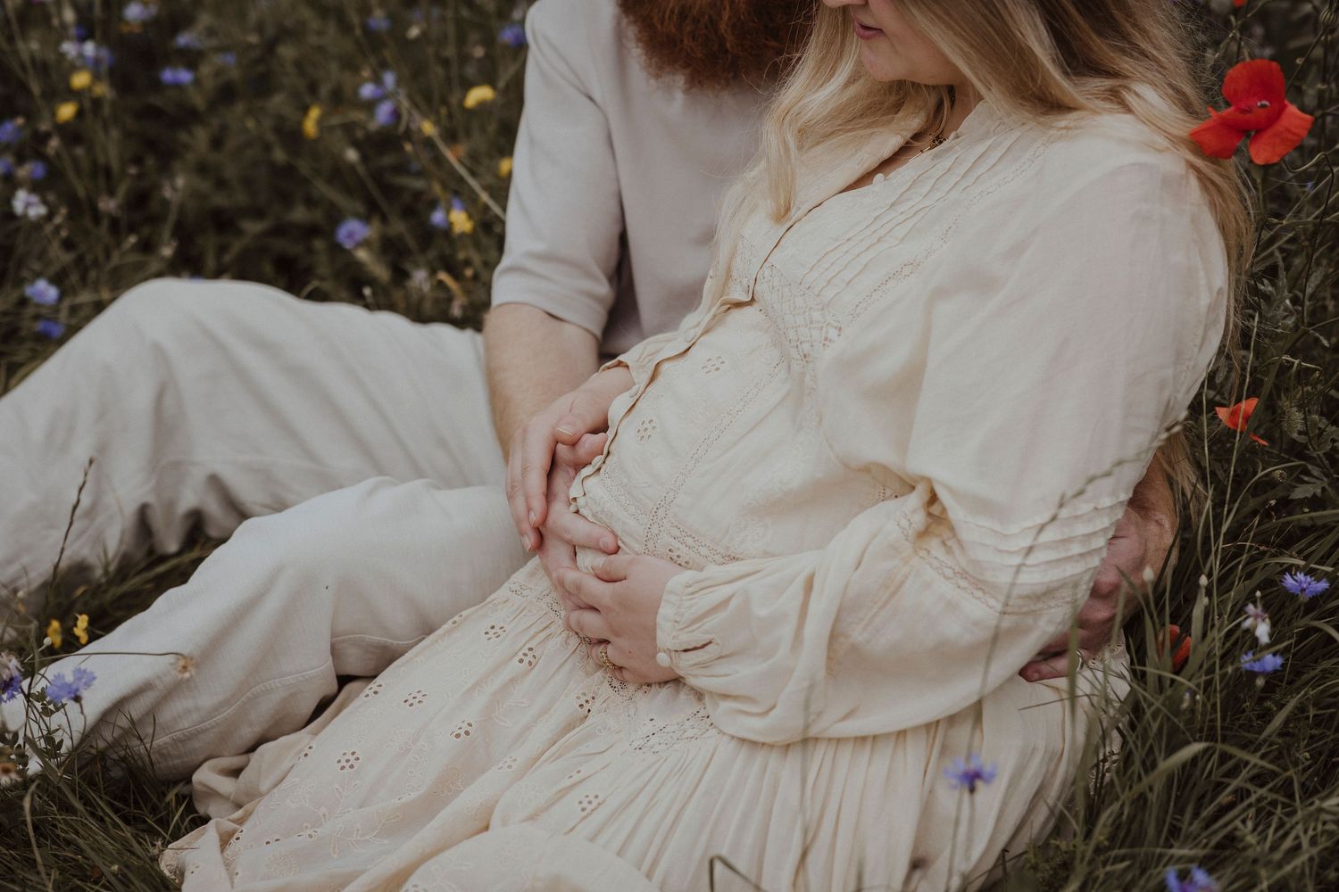 Wrapped in wildflowers, they cradle the promise of their growing little world.